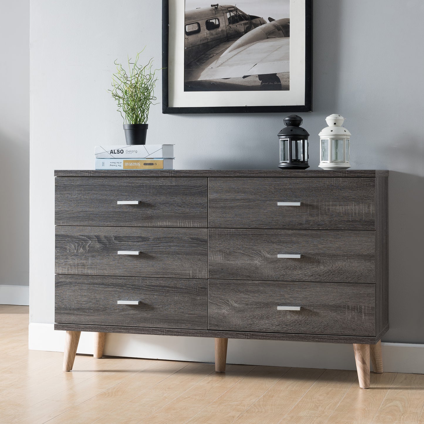 Left angled mid-century modern distressed gray six-drawer dresser in a bedroom with accessories