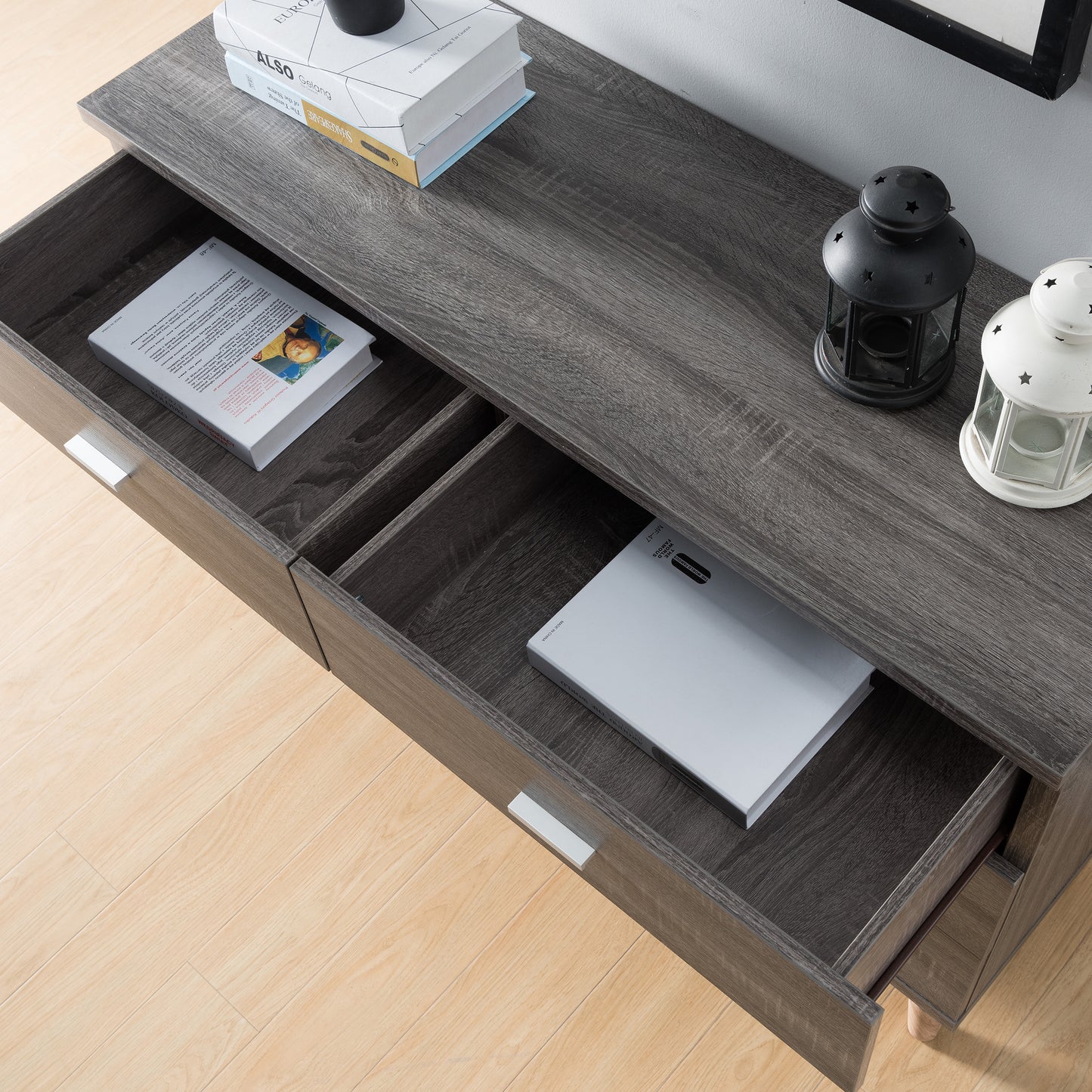 Left angled bird's eye close-up view of a mid-century modern distressed gray six-drawer dresser with top drawers open in a bedroom with accessories