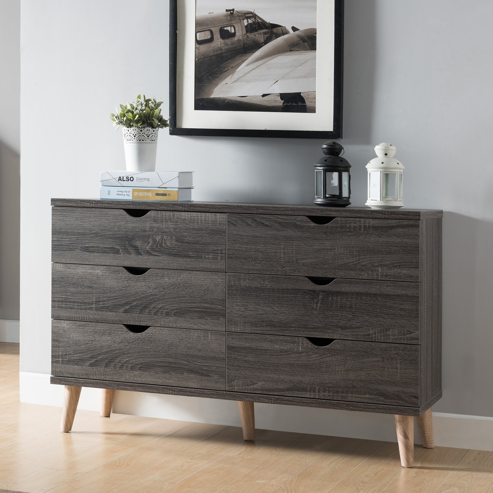 Left angled mid-century modern distressed gray six-drawer dresser in a bedroom with accessories