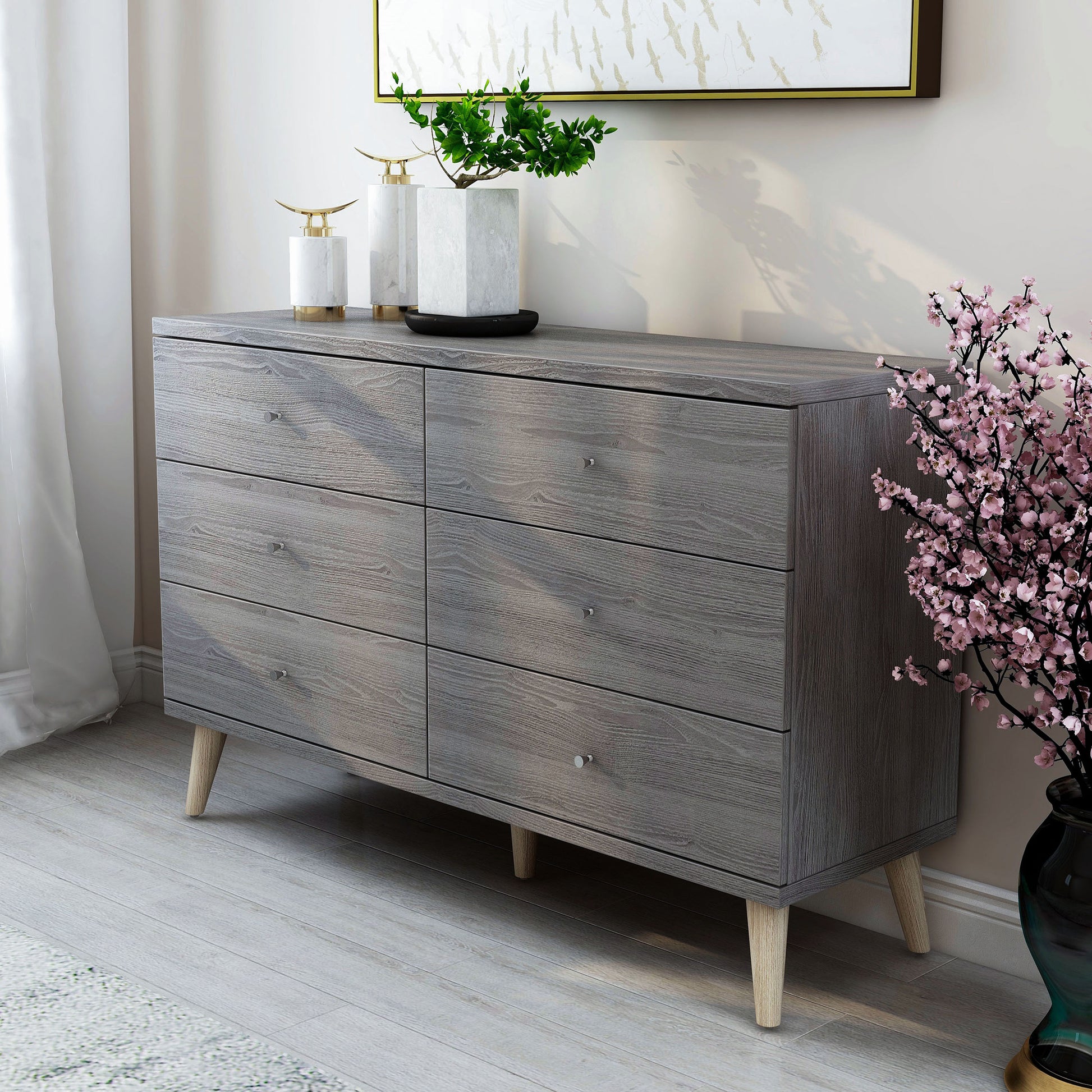 Left angled mid-century modern distressed gray six-drawer dresser in a bedroom with accessories