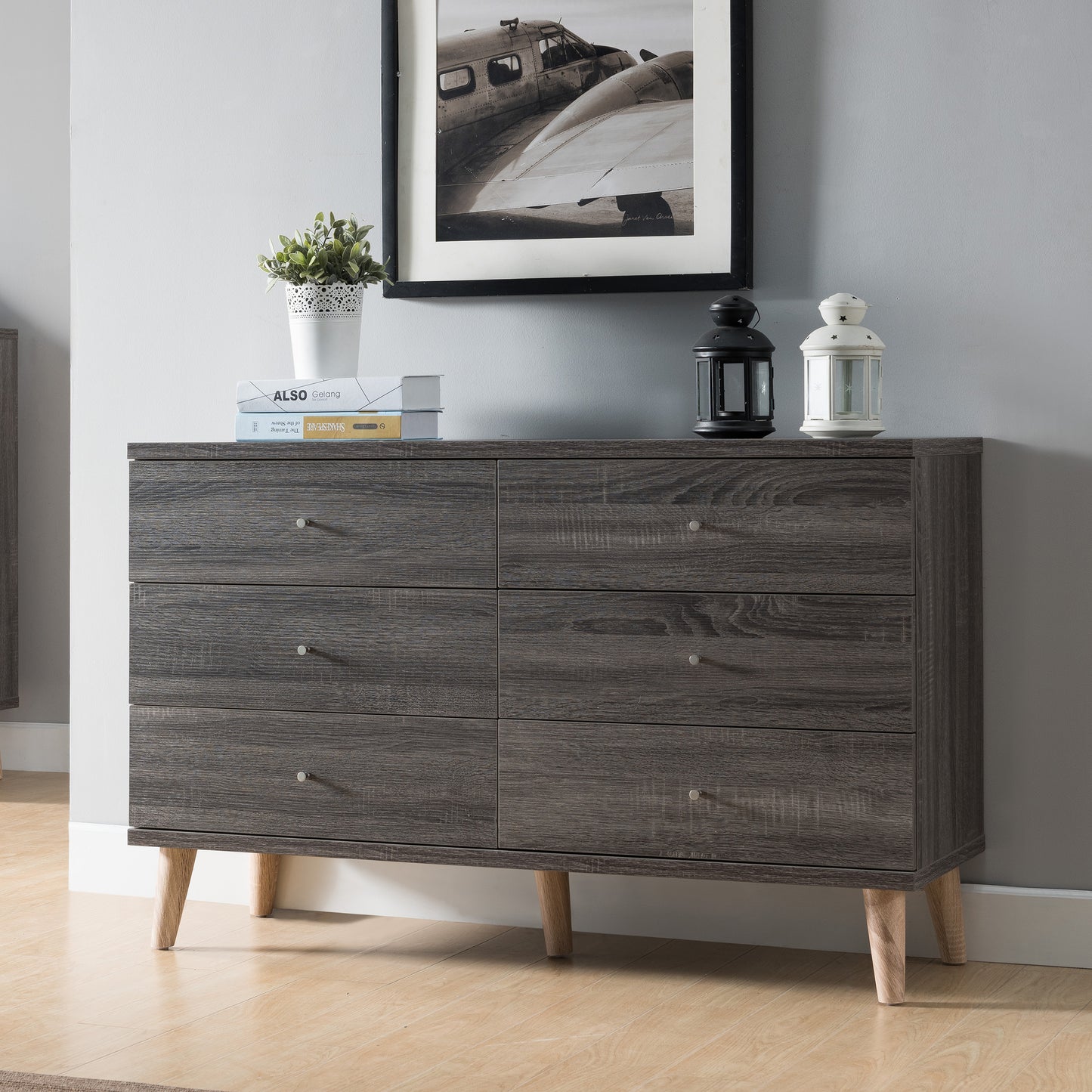 Left angled mid-century modern distressed gray six-drawer dresser in a bedroom with accessories