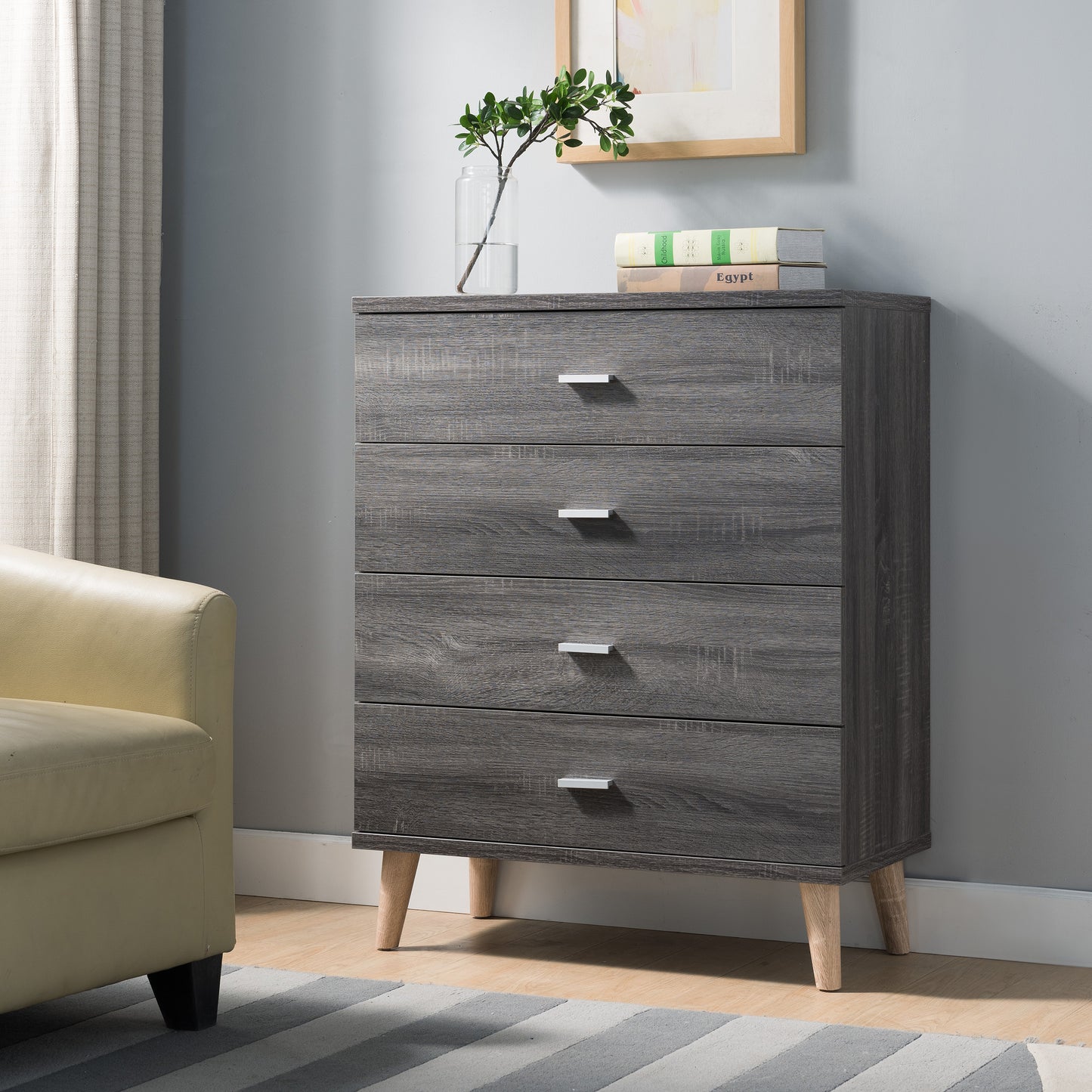 Left angled mid-century modern distressed gray four-drawer chest dresser in a living area with accessories