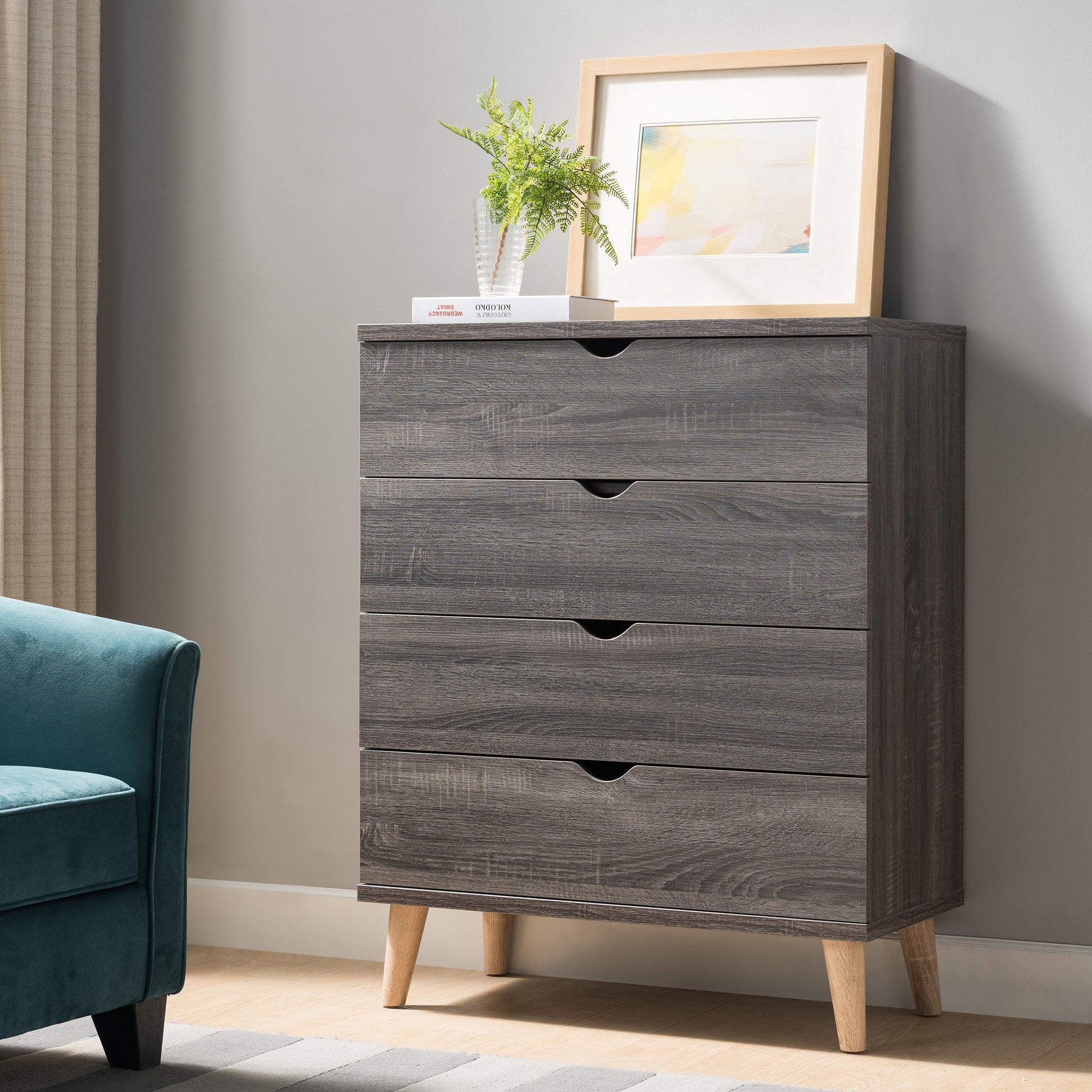 Left angled mid-century modern distressed gray four-drawer chest dresser in a living area with accessories