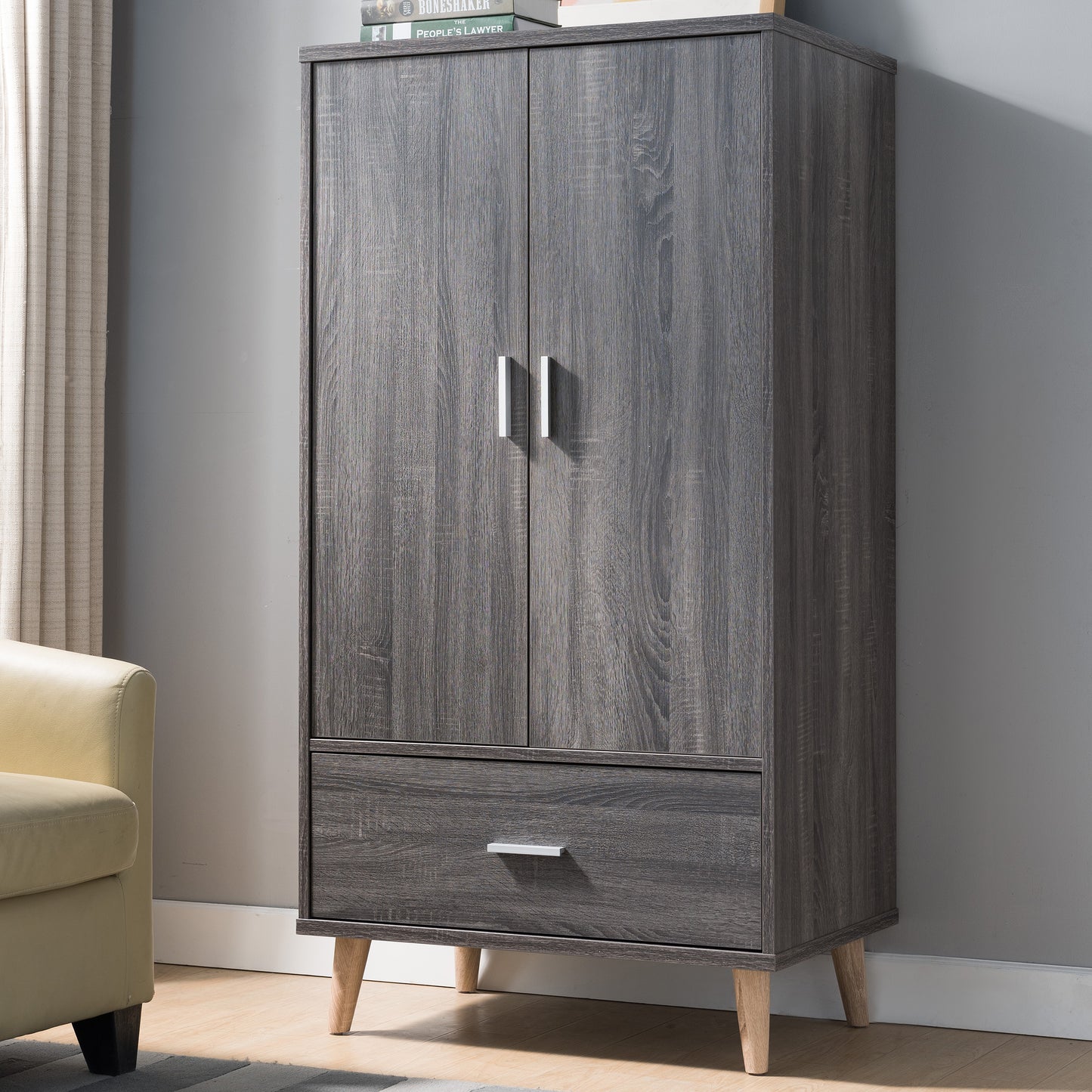 Left angled mid-century modern distressed gray two-door one-drawer wardrobe armoire in a bedroom with accessories