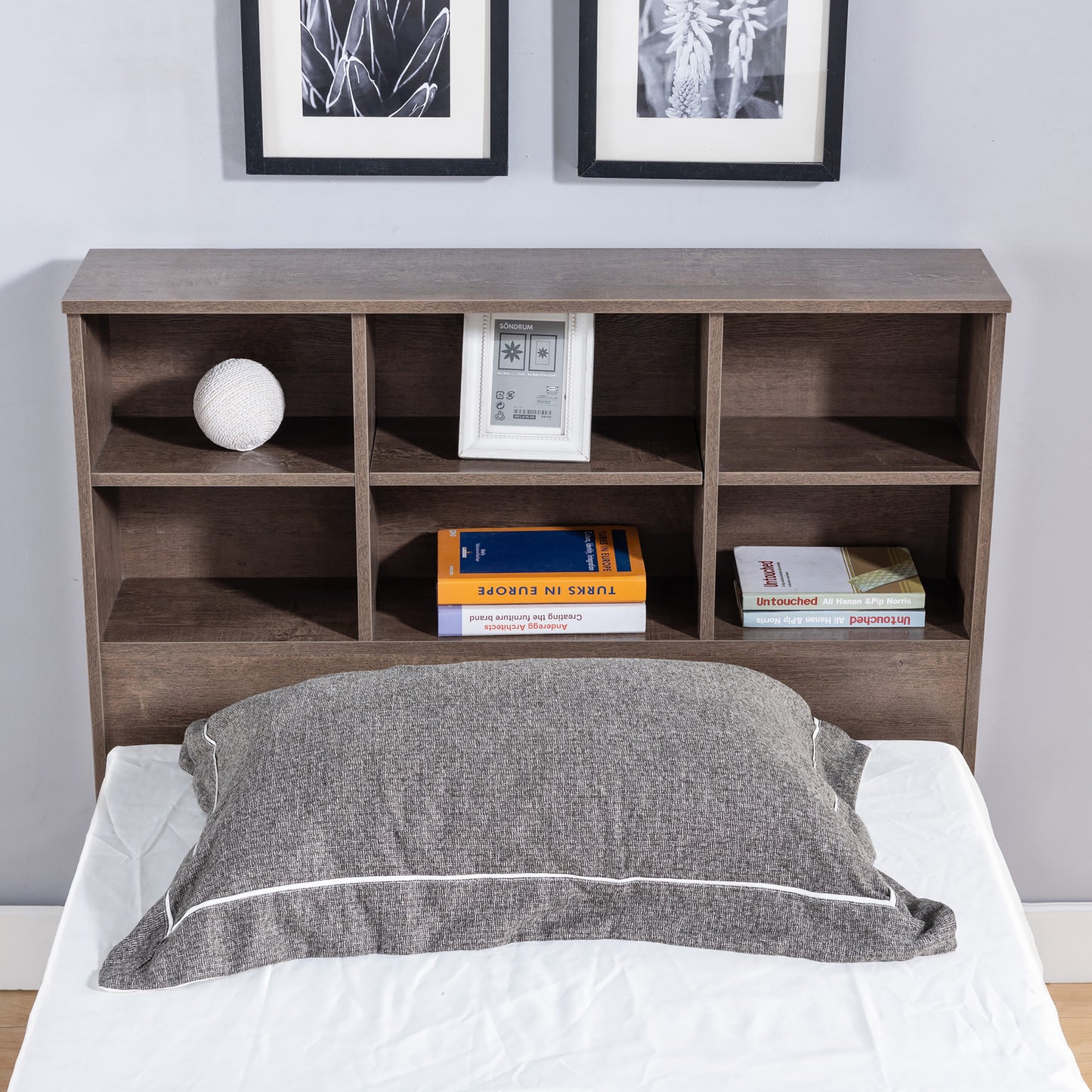 Front-facing transitional walnut six-shelf standing bookcase headboard in a bedroom with accessories