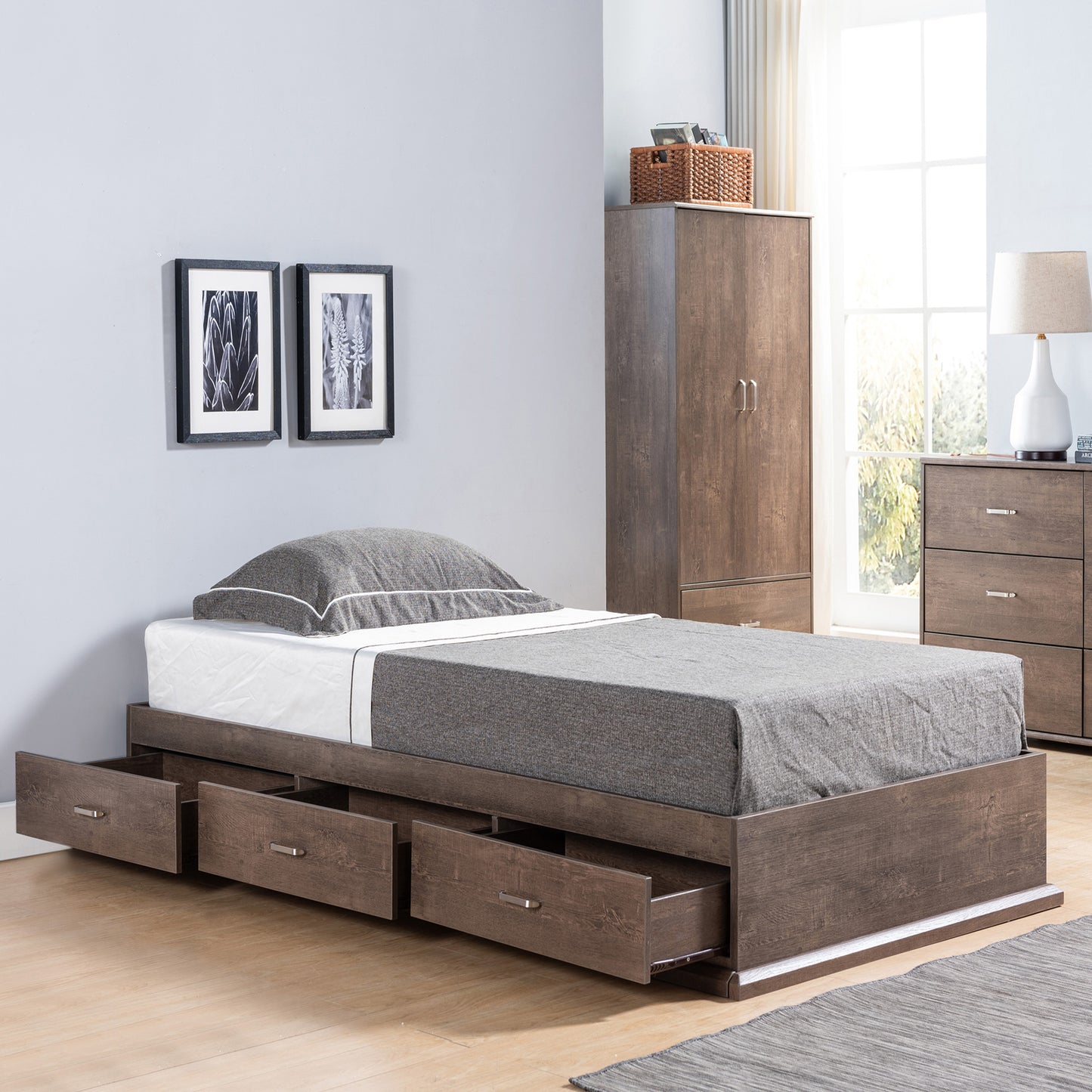 Right angled contemporary walnut three-drawer platform storage bed with drawers open in a bedroom with accessories