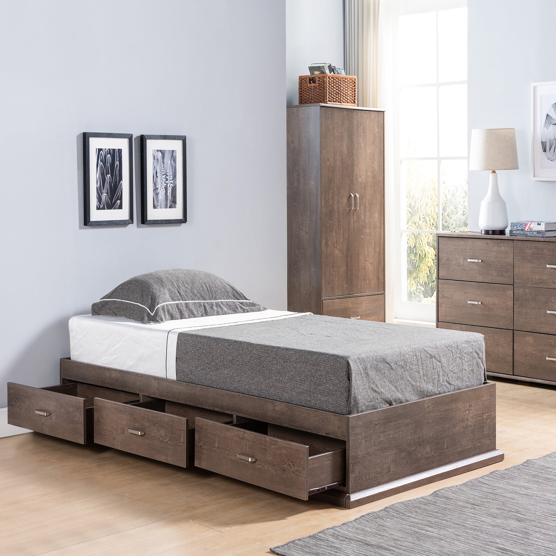 Right angled contemporary walnut three-drawer platform storage bed with drawers open in a bedroom with accessories