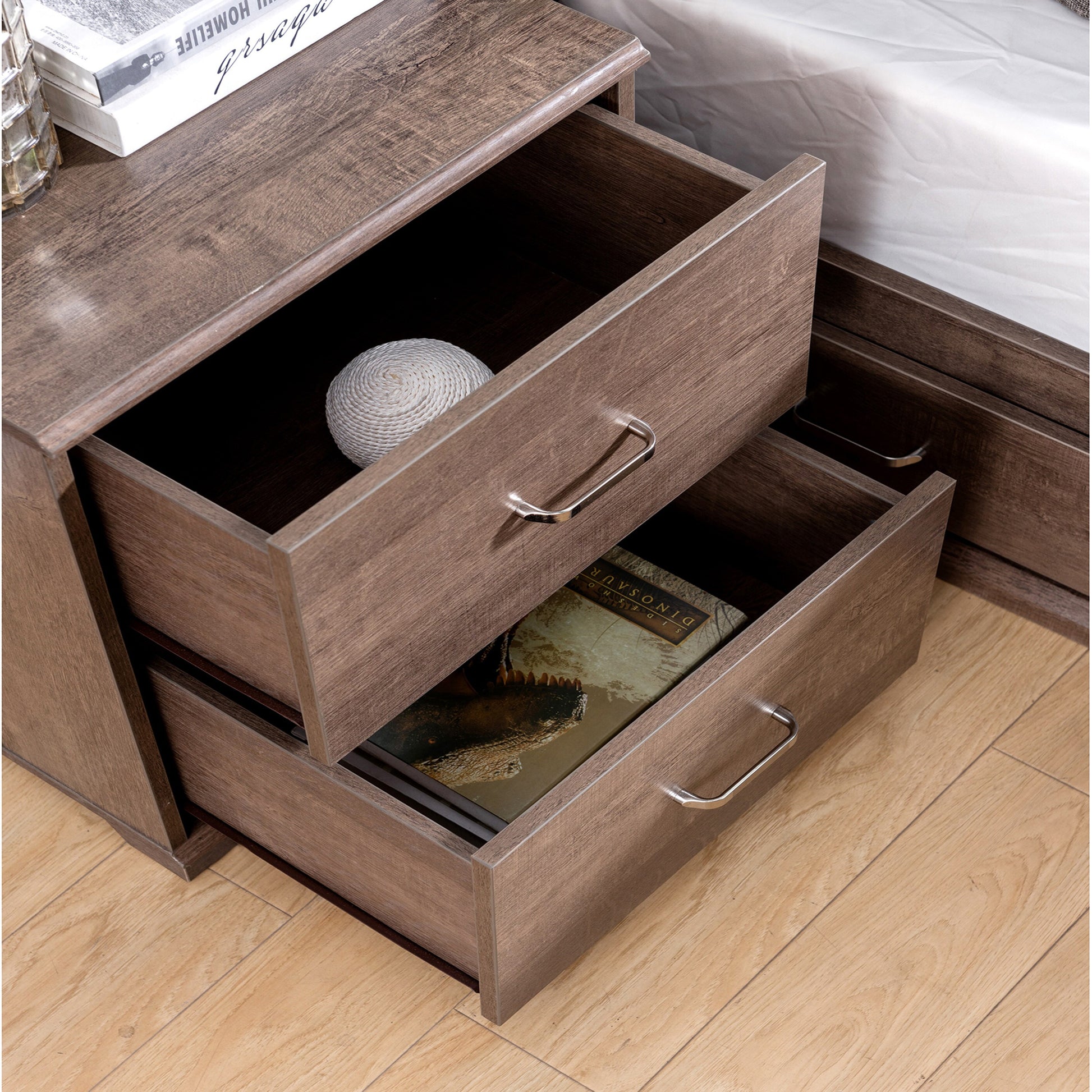 Right angled bird's eye view of a transitional walnut two-drawer nightstand with drawers open in a bedroom with accessories