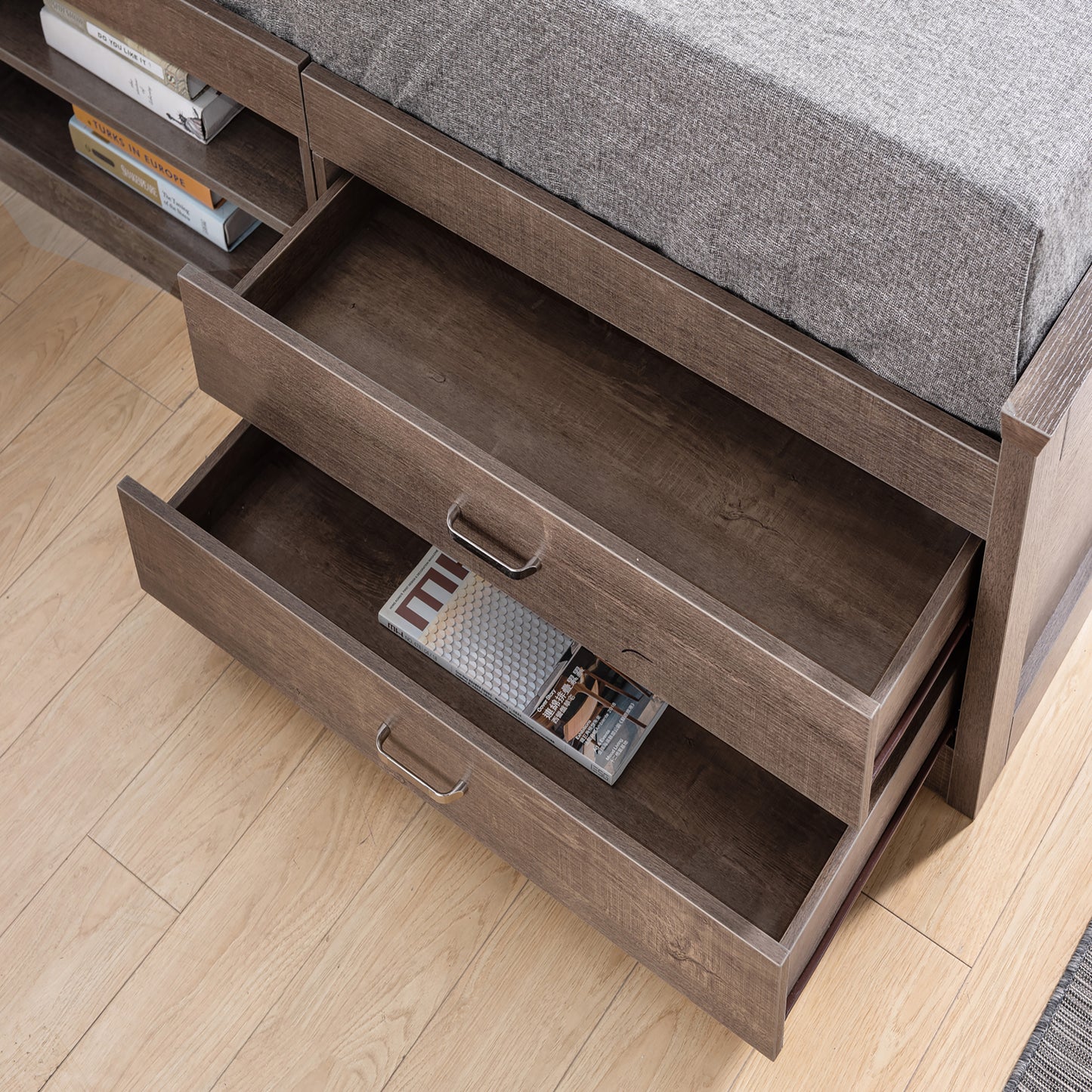 Right angled matching bed with drawers open for a transitional walnut six-shelf bookcase headboard in a bedroom with accessories