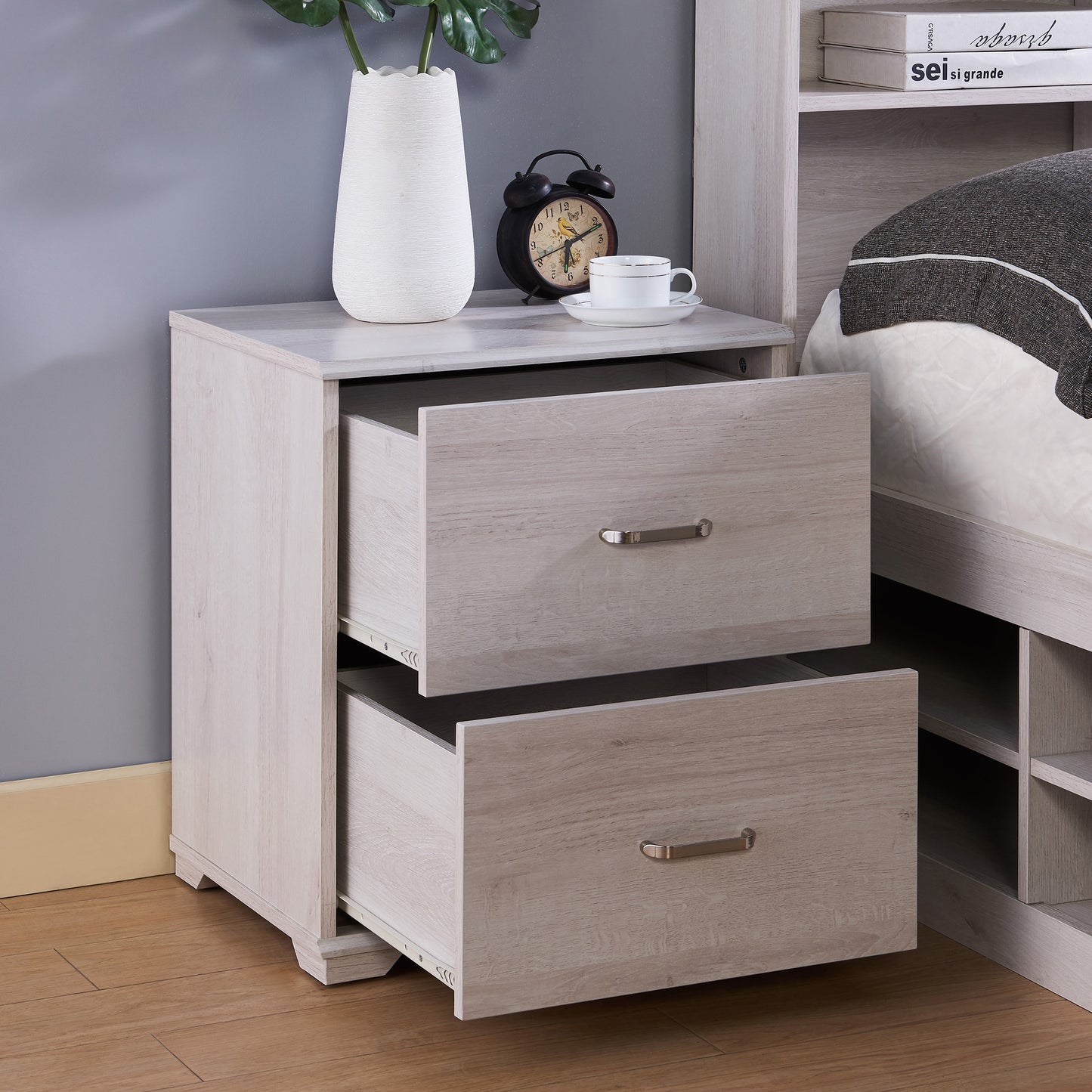 Right angled transitional white oak two-drawer nightstand with drawers open in a bedroom with accessories