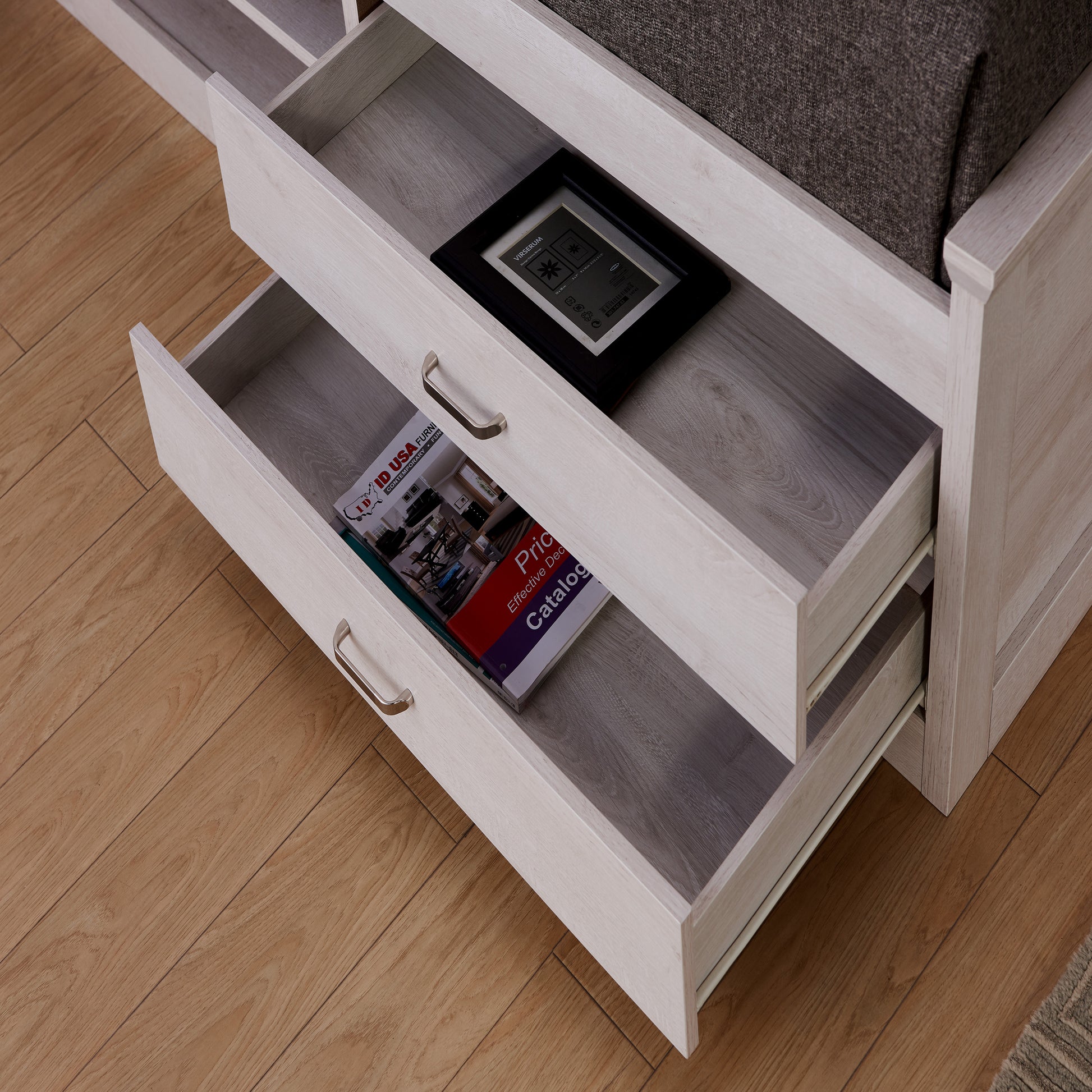 Right angled bird's eye close up view of a transitional two-drawer four-shelf platform storage bed with drawers open in a bedroom with accessories