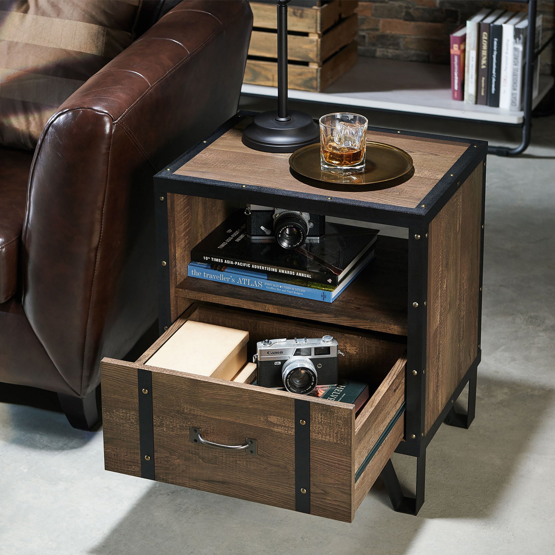 Left angled industrial reclaimed oak and black one shelf one drawer end table with drawer open in a living room with accessories