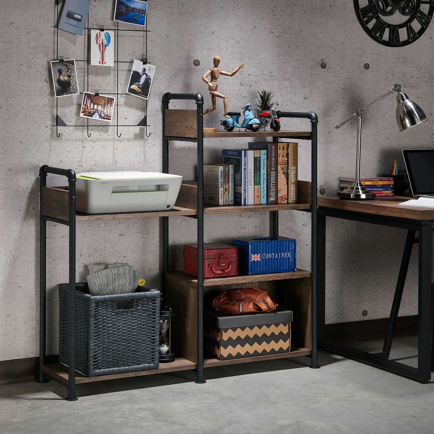 Left angled industrial reclaimed oak and black water pipe six-shelf open bookcase in a home office with accessories