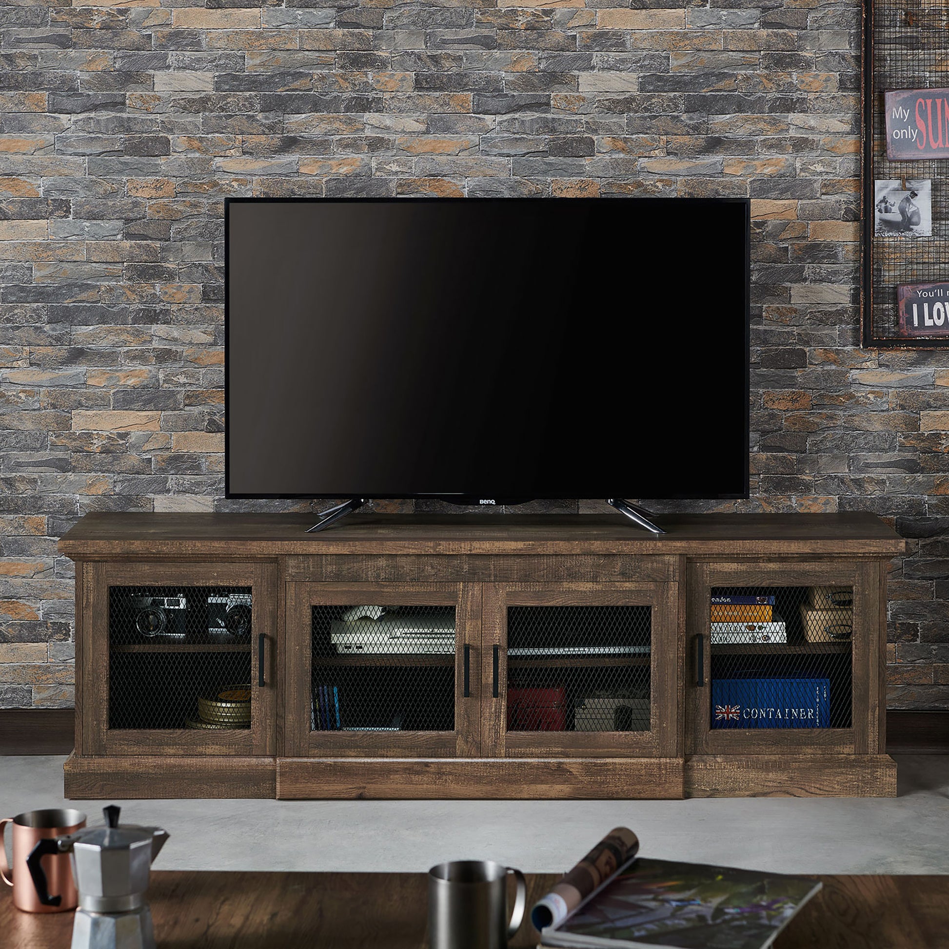 Front-facing rustic reclaimed oak six-shelf TV stand with mesh doors in a living room with accessories