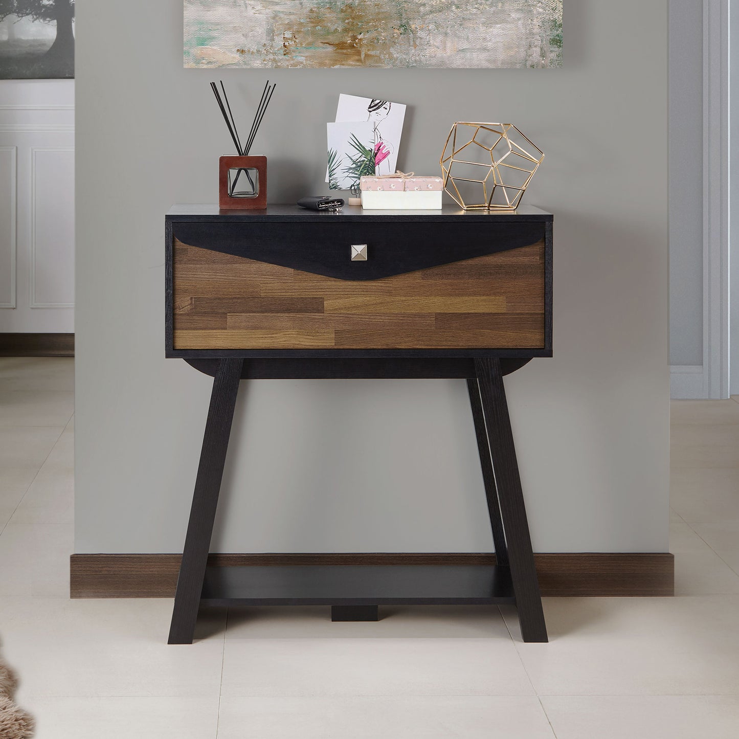 Front-facing modern black and wood one-drawer console table with a shelf in a living room with accessories