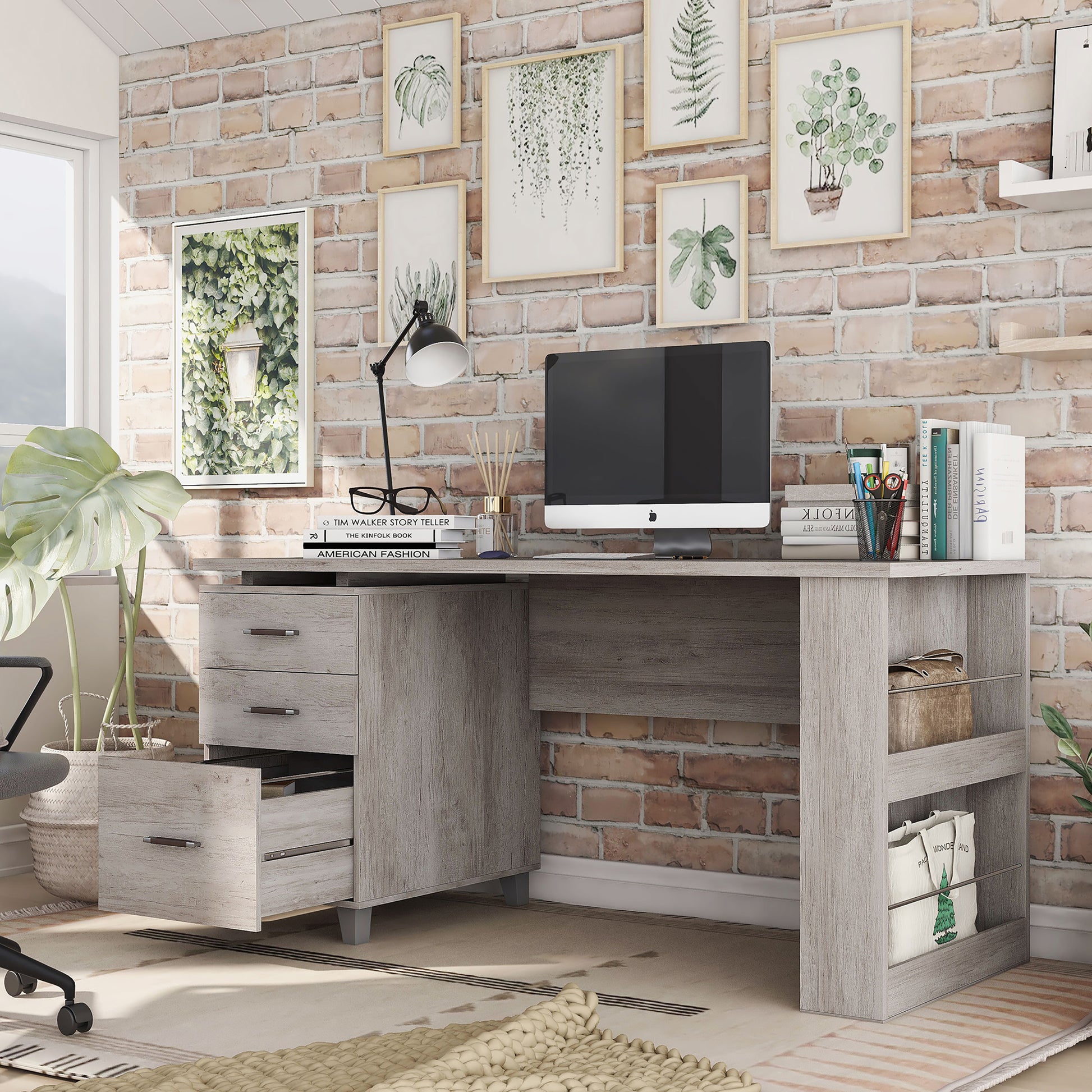 Left angled transitional coastal white three-drawer office desk with magazine racks and bottom drawer open in a home office with accessories