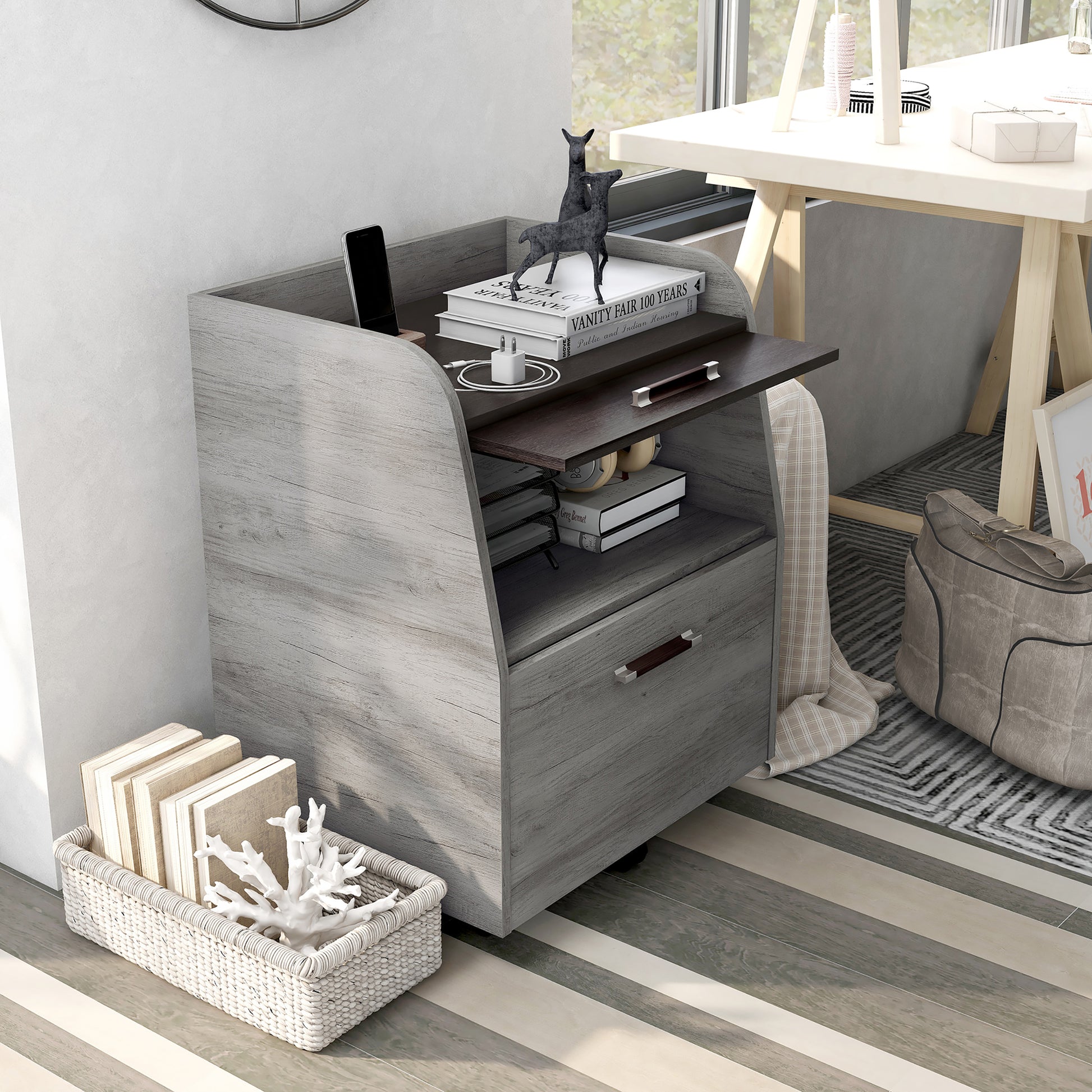Right angled bird's eye view of a transitional vintage gray oak and wenge one-drawer mobile file pedestal with door raised in a living area with accessories