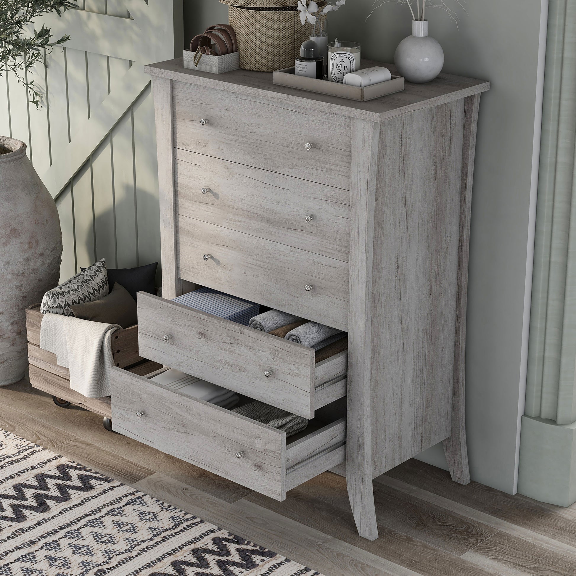 Left angled bird's eye view of a transitional coastal white five-drawer chest with two drawers open in a living area with accessories