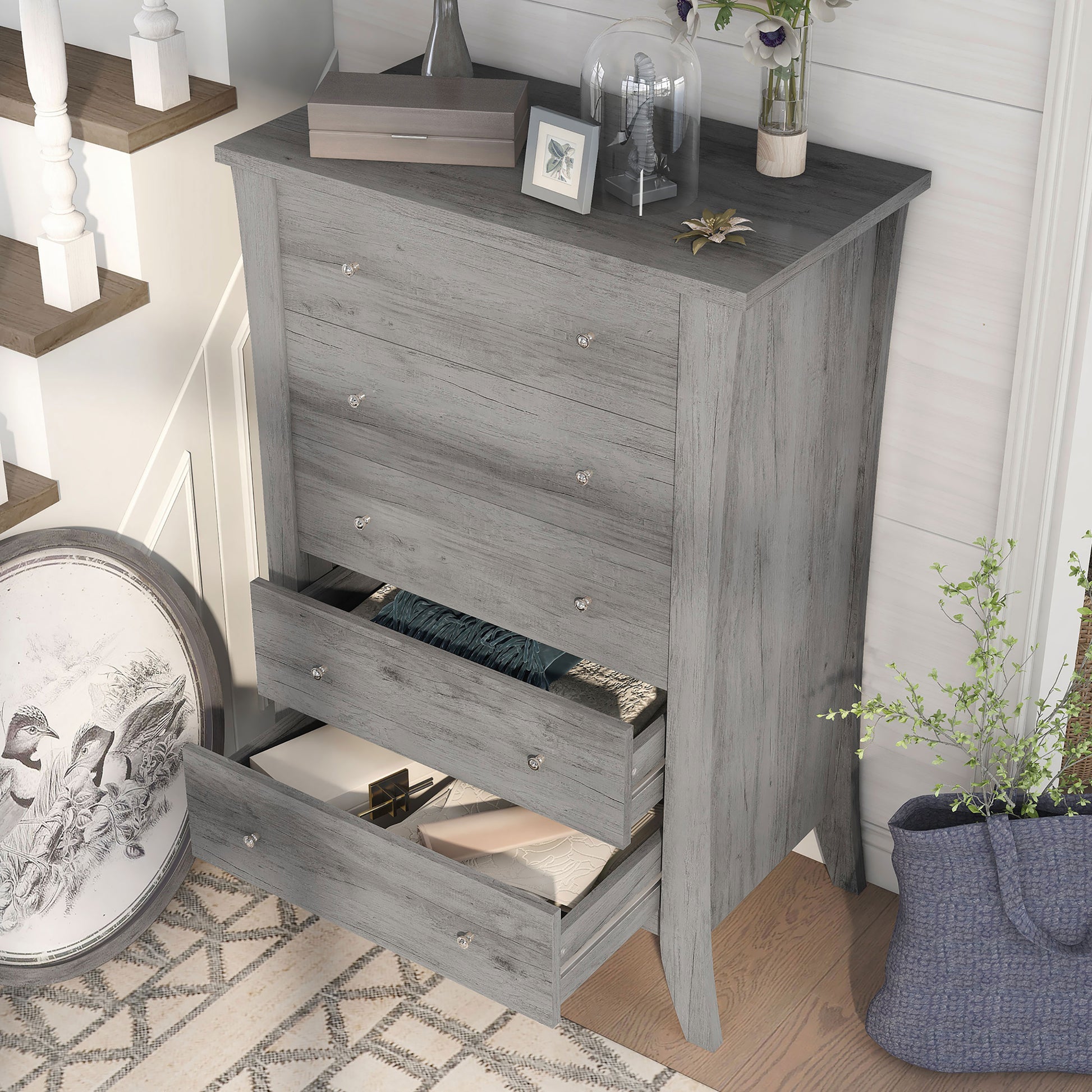 Left angled bird's eye view of a transitional vintage gray oak five-drawer chest with two drawers open in a living area with accessories