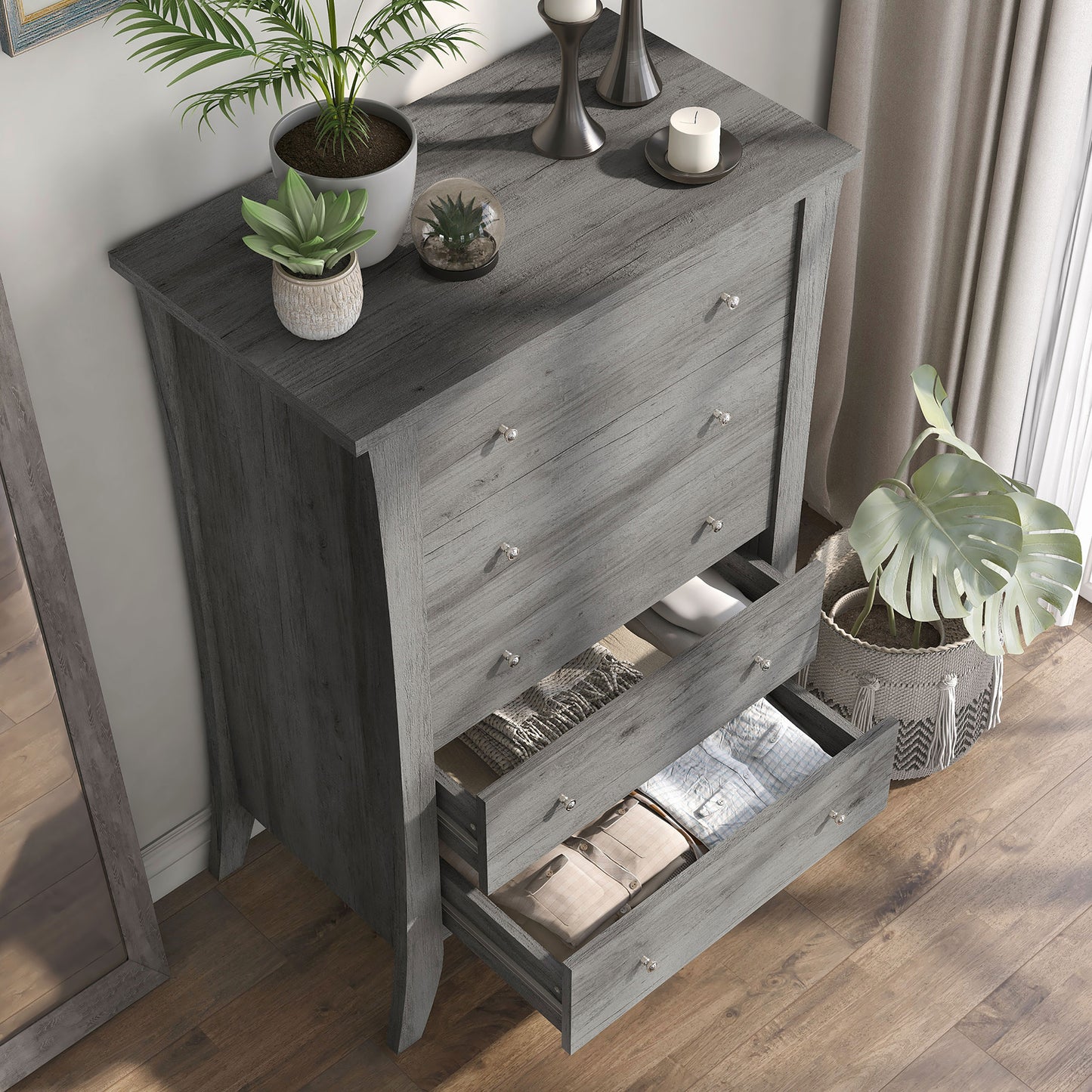 Right angled bird's eye view of a transitional vintage gray oak five-drawer chest with two drawers open in a bedroom with accessories