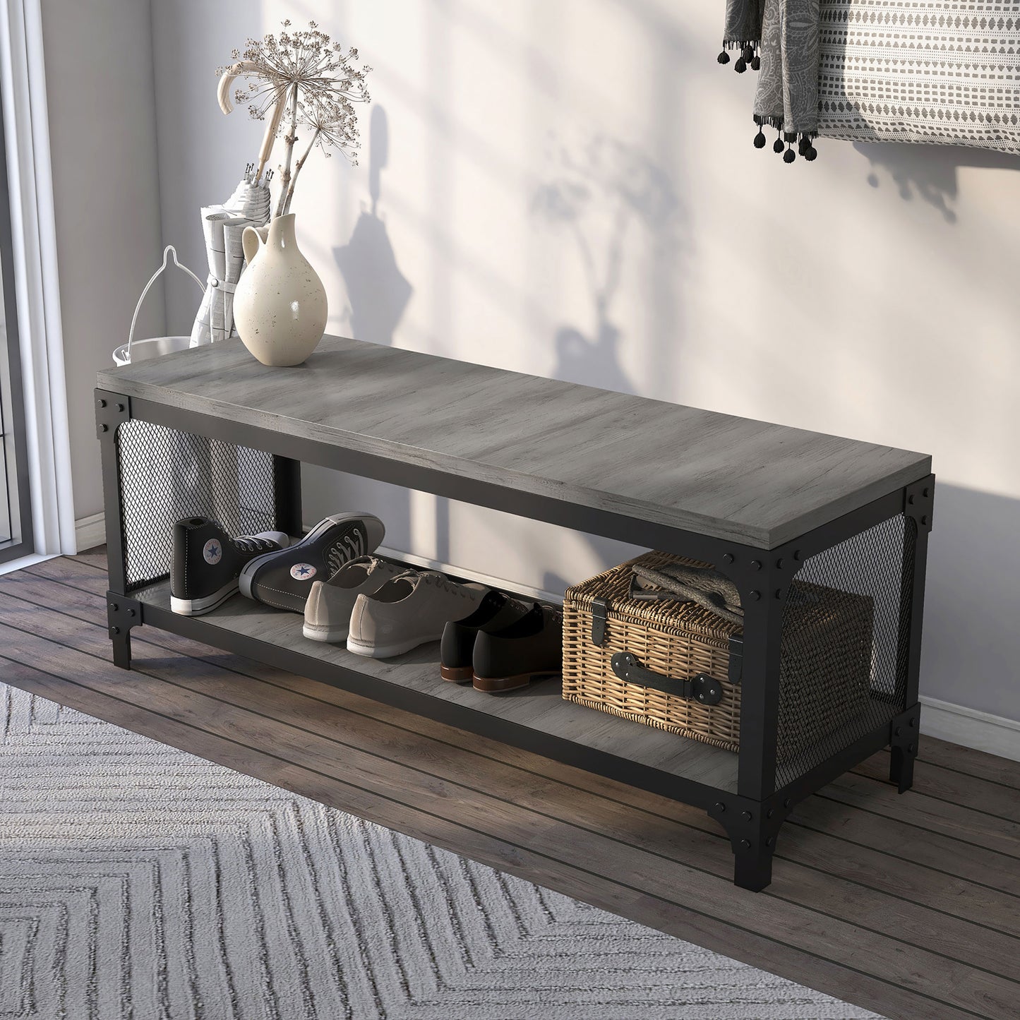 Left angled industrial vintage gray oak shoe storage bench with a shelf in an entry with accessories