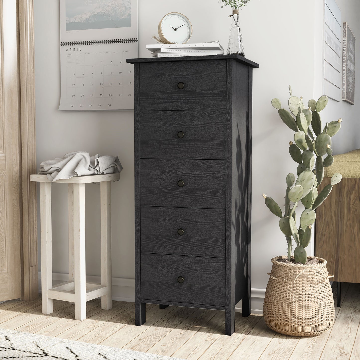 Left angled transitional black slim five-drawer chest in a living area with accessories