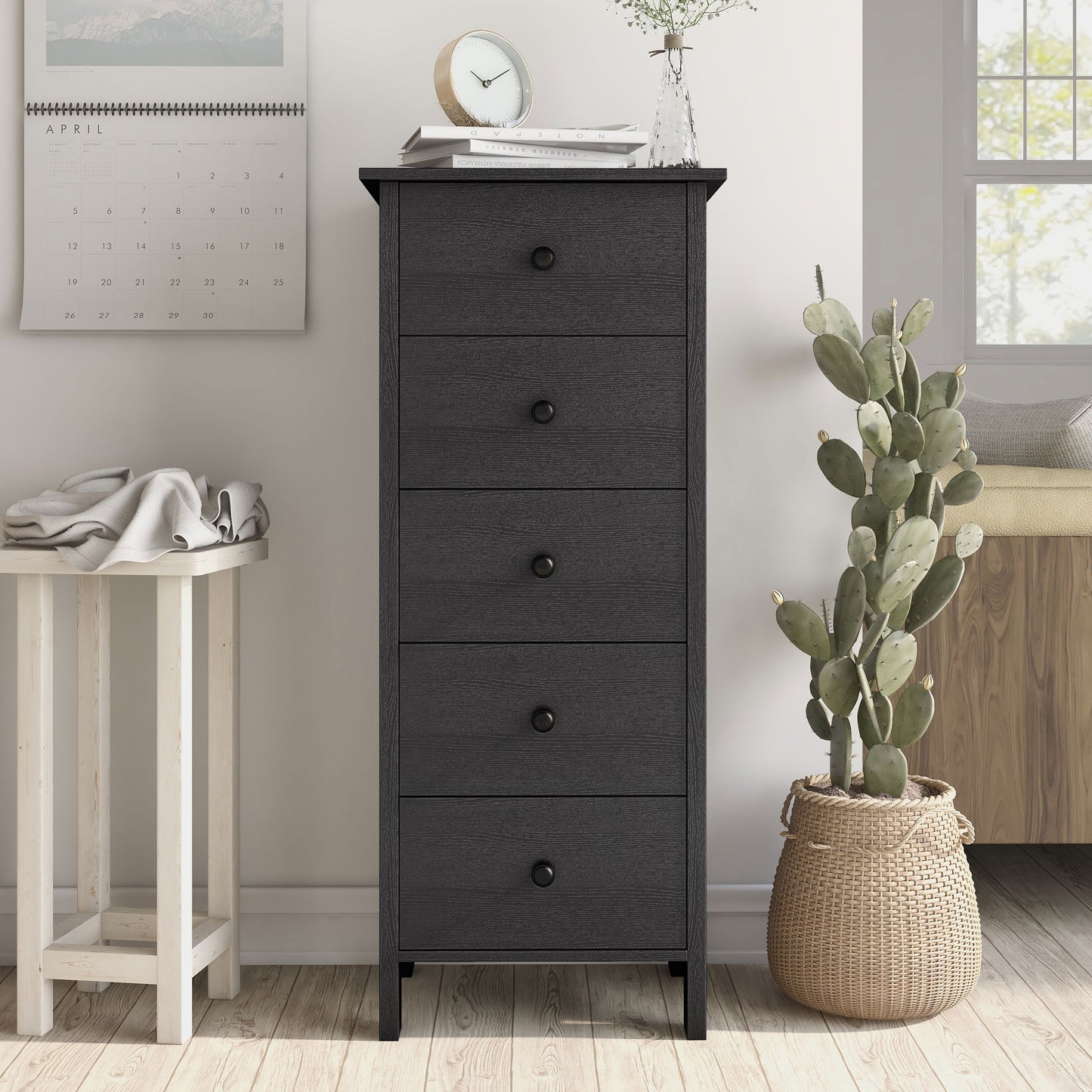Front-facing transitional black slim five-drawer chest in a living area with accessories
