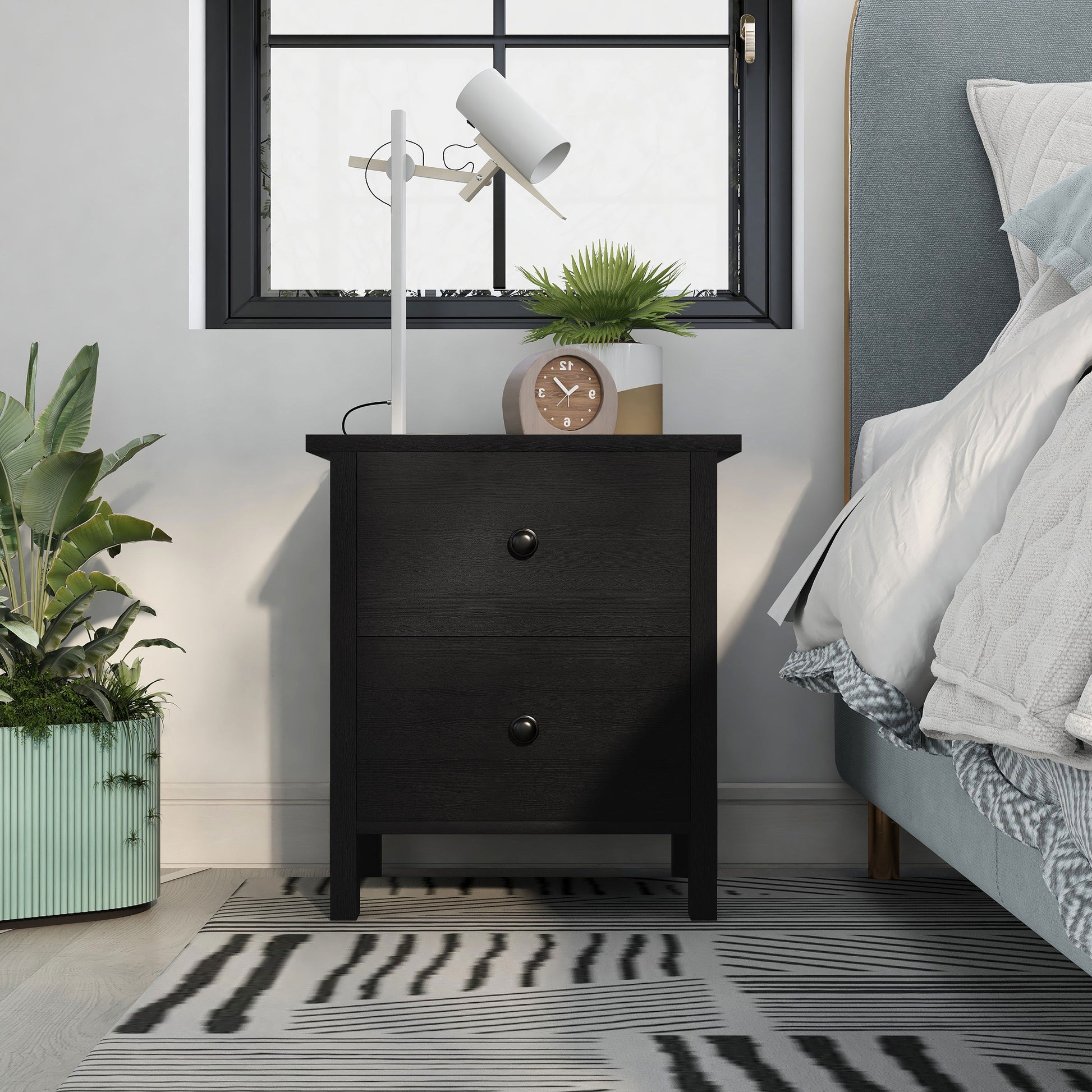 Front-facing transitional black two-drawer nightstand in a bedroom with accessories