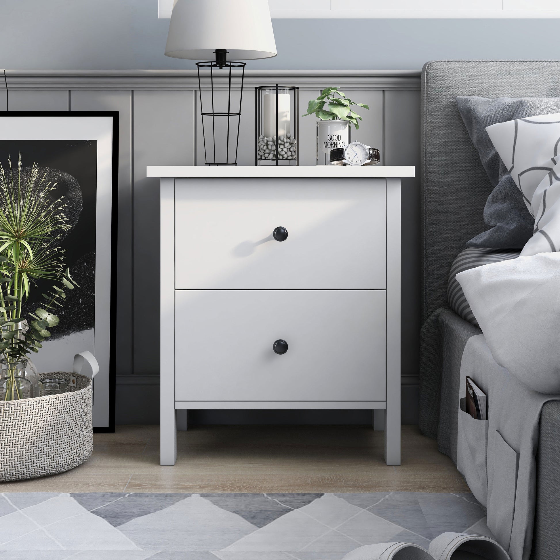 Front-facing transitional white two-drawer nightstand in a bedroom with accessories