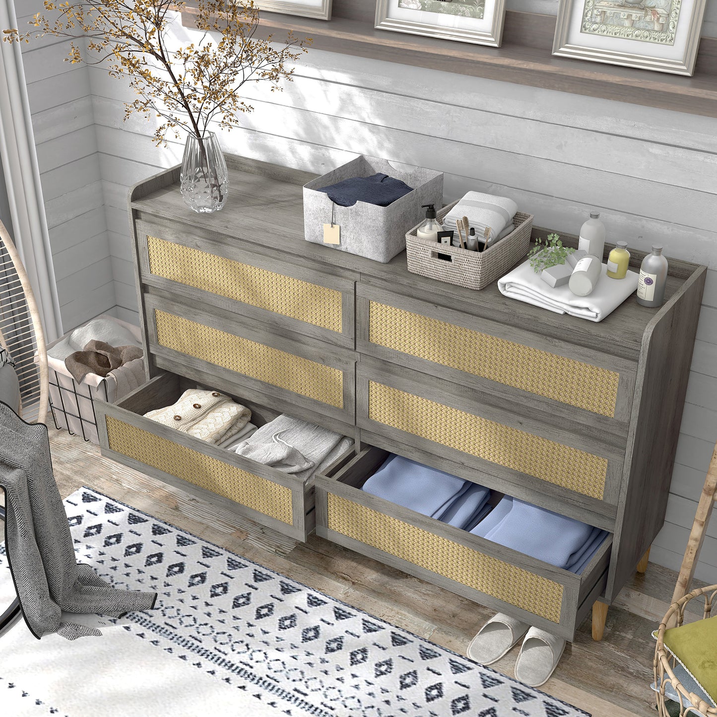 Left angled bird's eye view of a mid-century modern vintage gray oak and rattan six-drawer dresser with lower drawers open in a bedroom with accessories