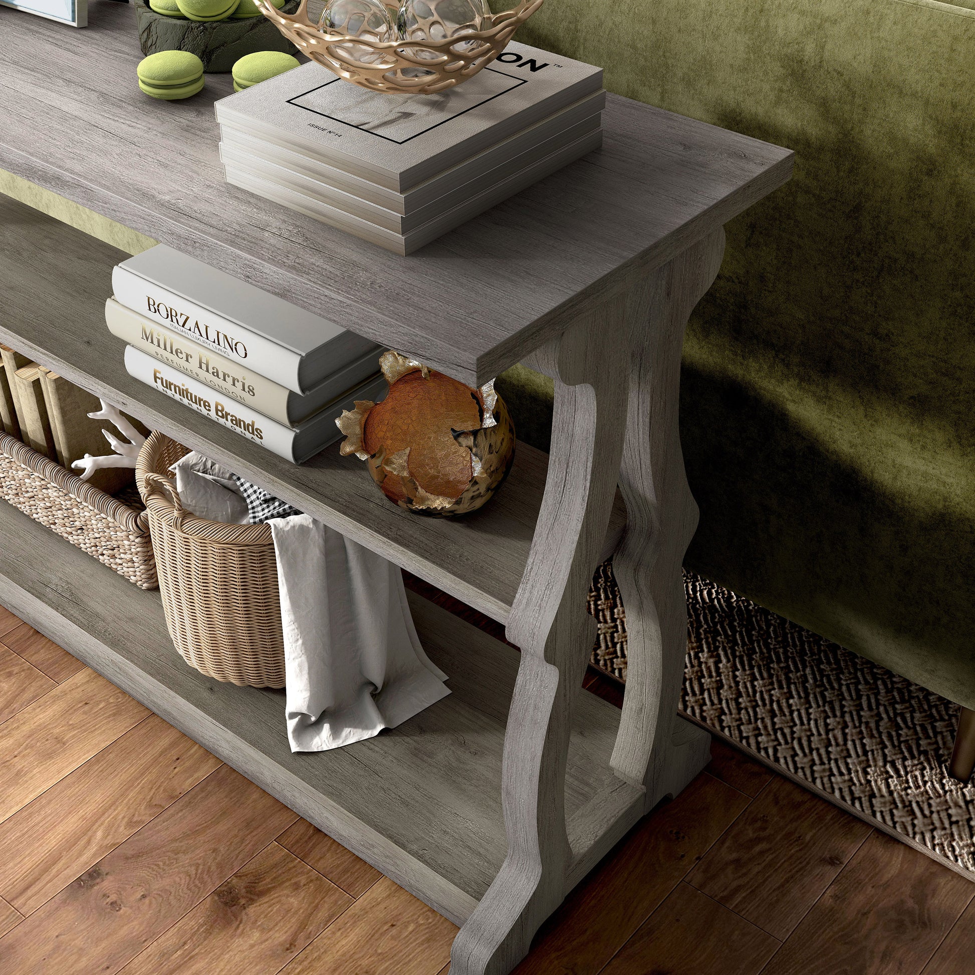 Left angled close up view of a farmhouse vintage gray oak sofa table with scroll legs in a living room with accessories