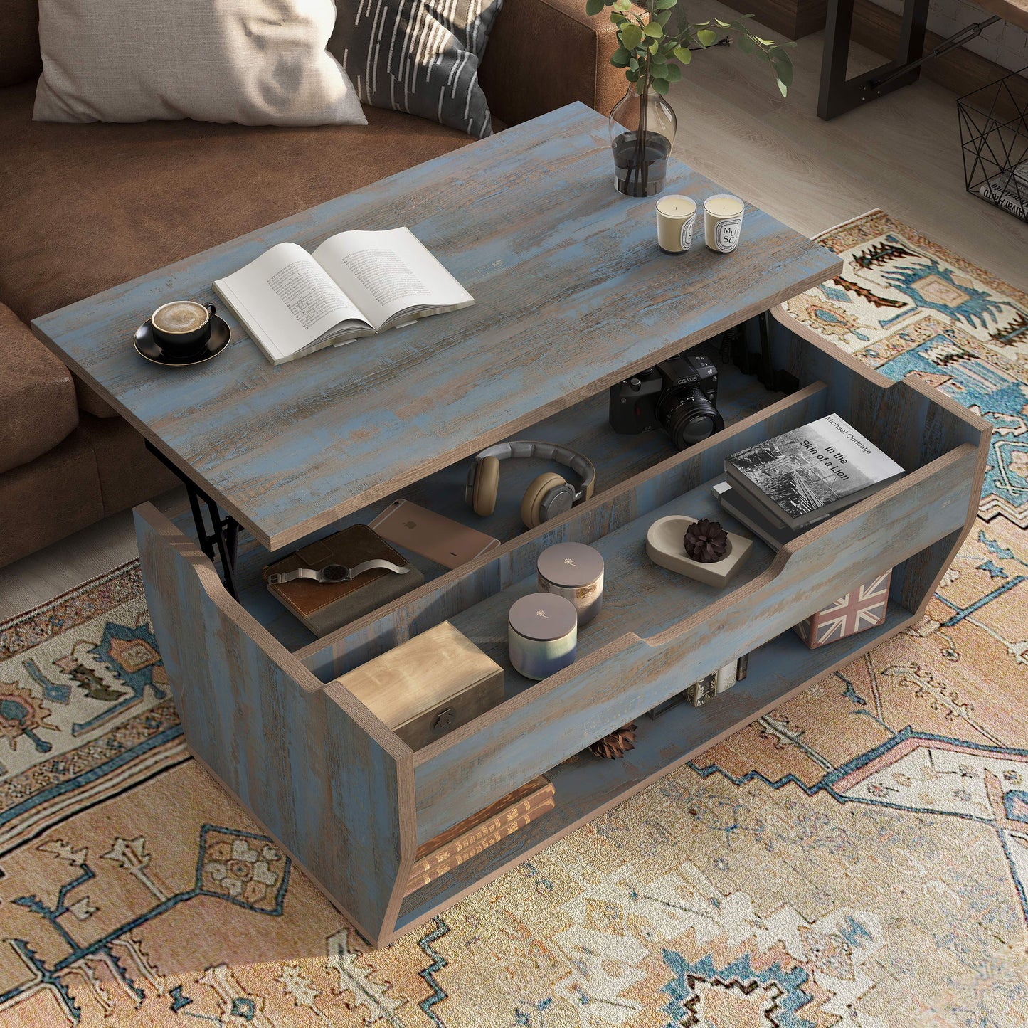 Right angled bird's eye view of a rustic distressed blue lift-top storage coffee table with top up in a living room with accessories