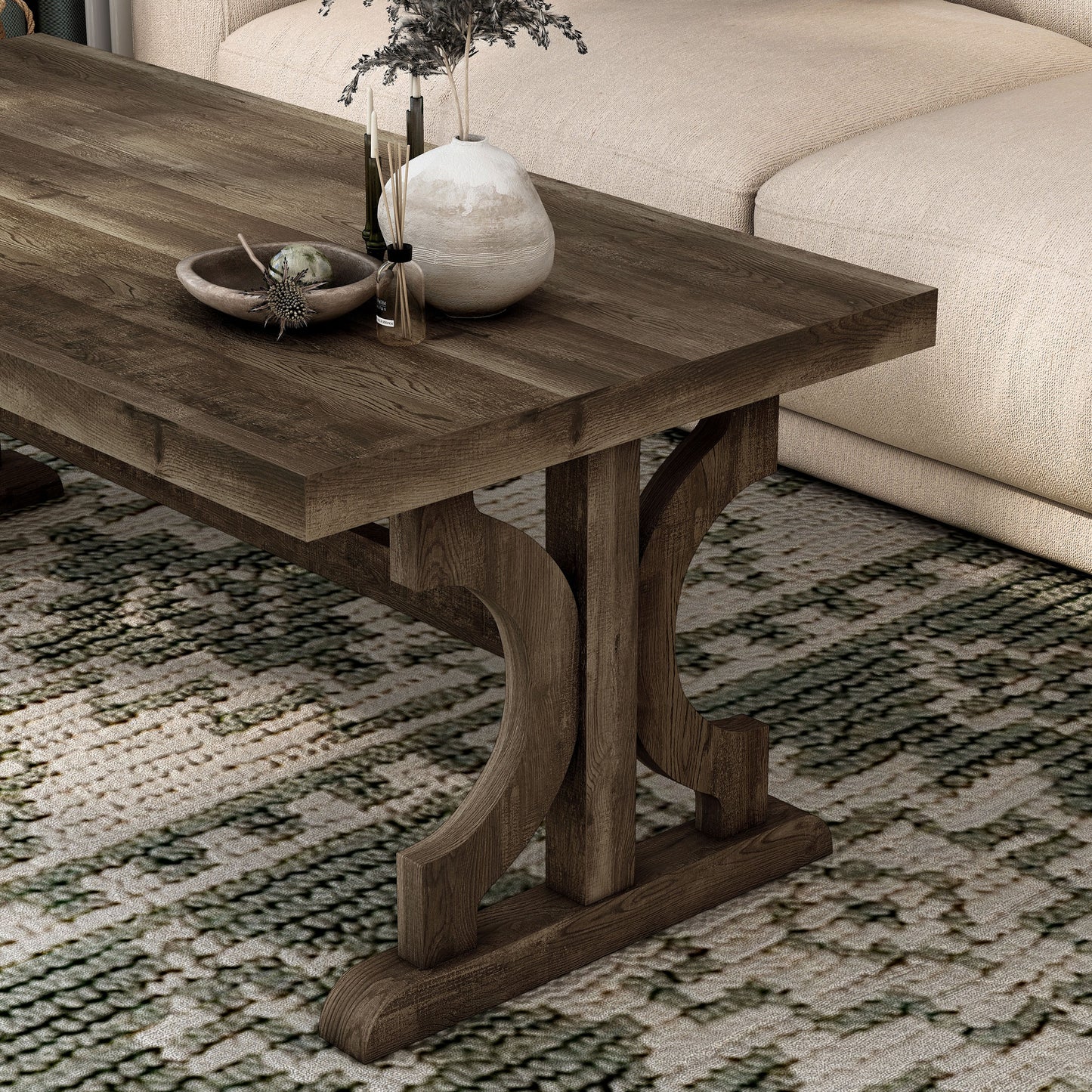 Left angled close-up view of a farmhouse reclaimed oak trestle base coffee table in a living room with accessories