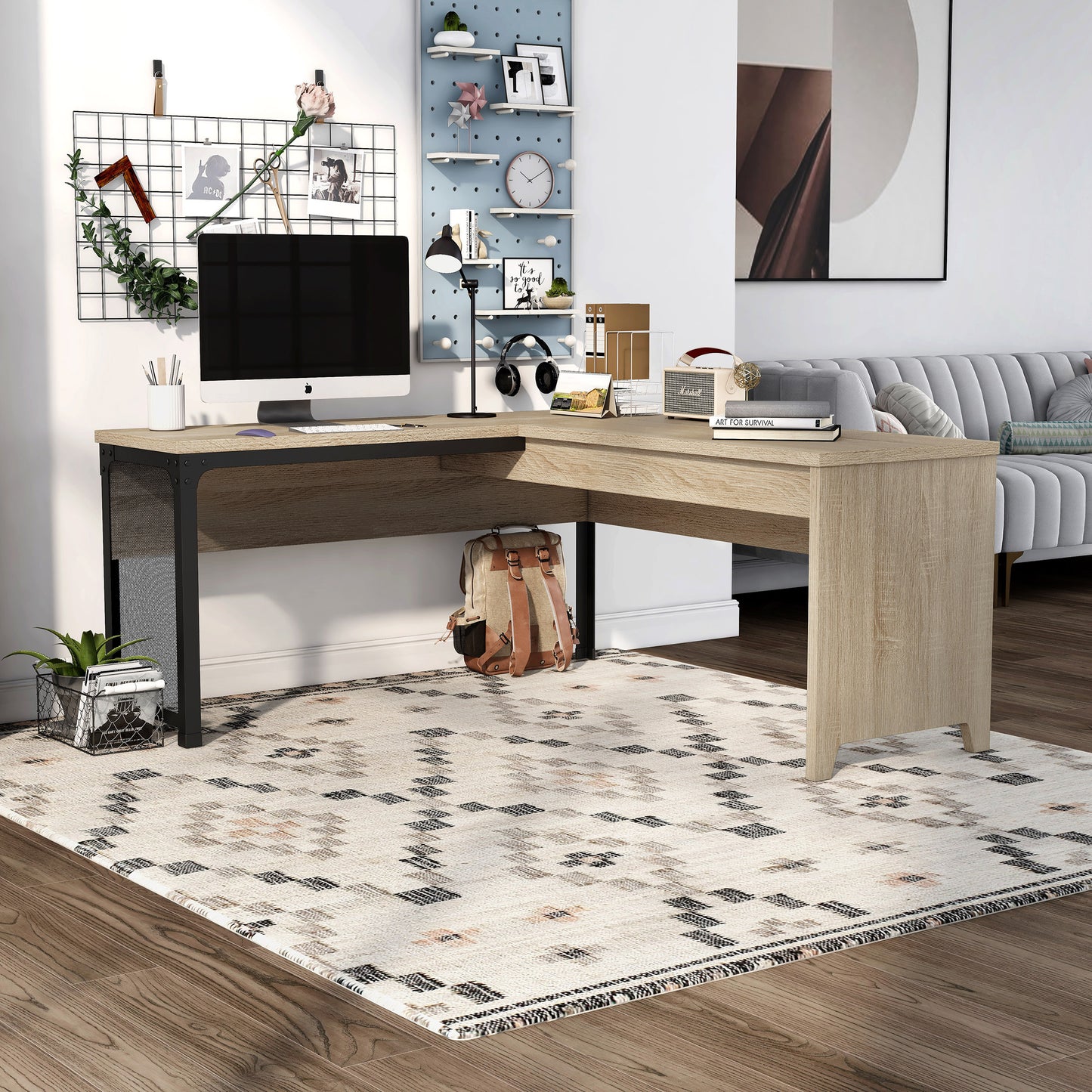 Angled industrial natural oak and black mesh L-shaped corner desk with a lift top in a home office with accessories