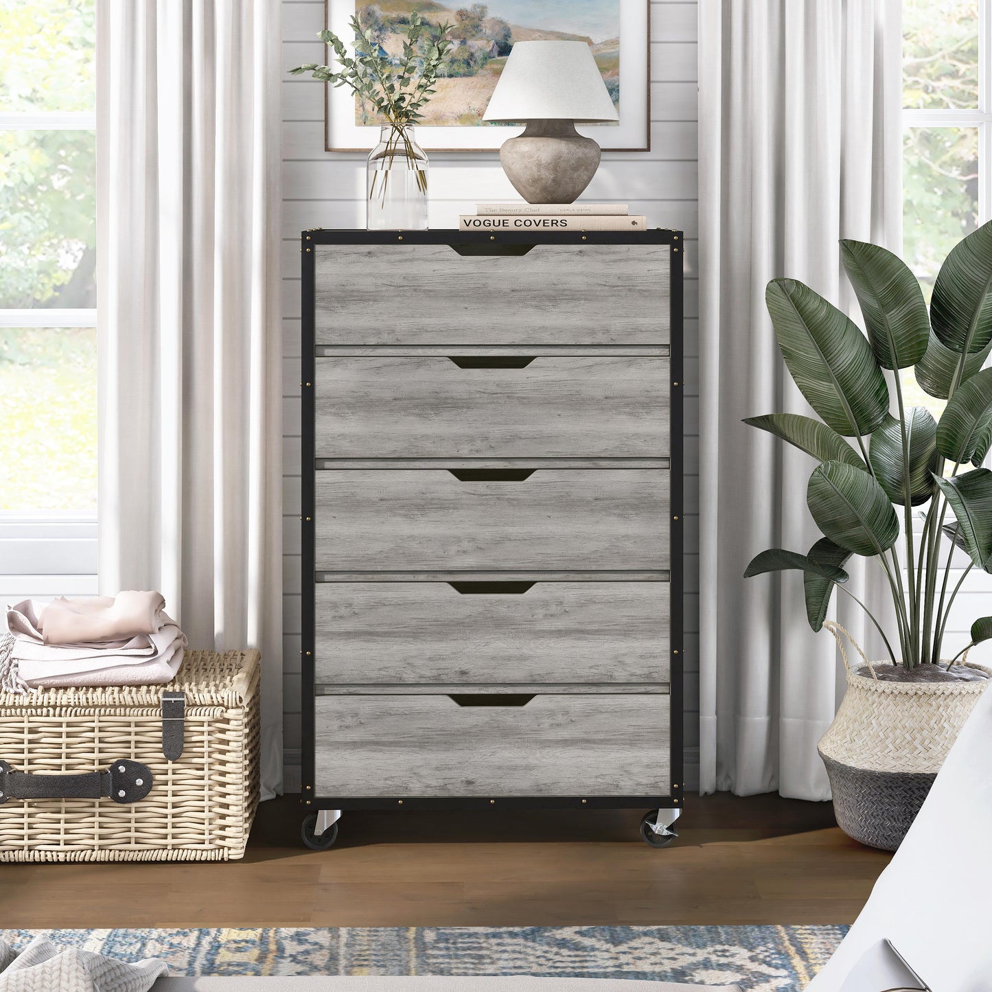 Front-facing industrial vintage gray oak and black five-drawer mobile chest dresser in a living area with accessories