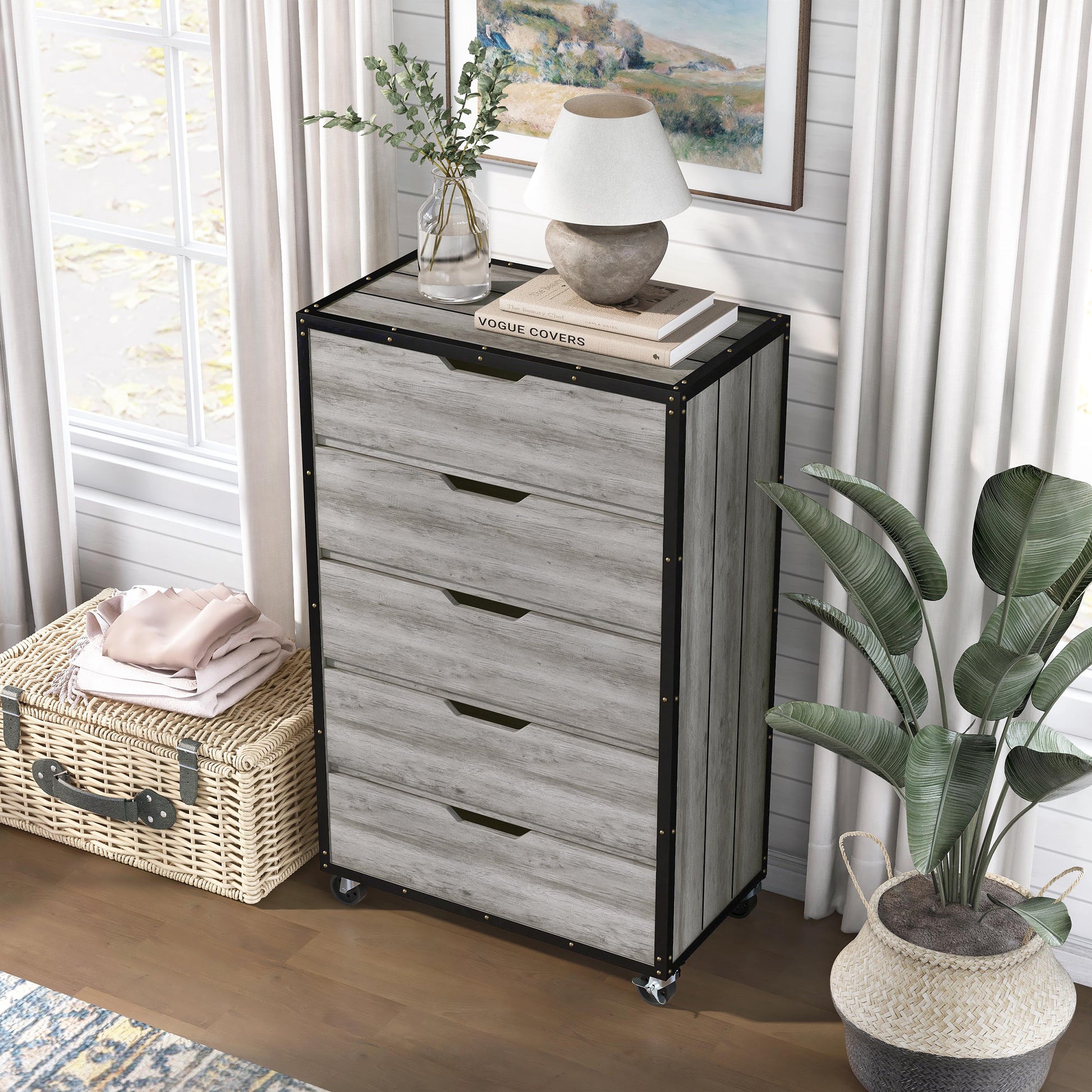 Left angled bird's eye view of an industrial vintage gray oak and black five-drawer mobile chest dresser in a living area with accessories