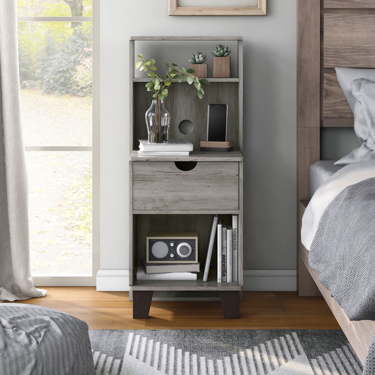 Front-facing transitional vintage gray oak three-shelf nightstand with one drawer in a bedroom with accessories