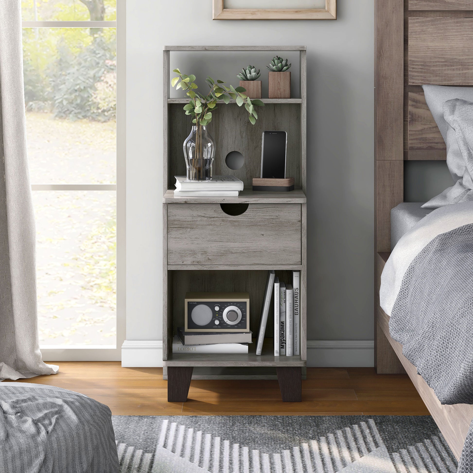 Front-facing transitional vintage gray oak three-shelf nightstand with one drawer in a bedroom with accessories