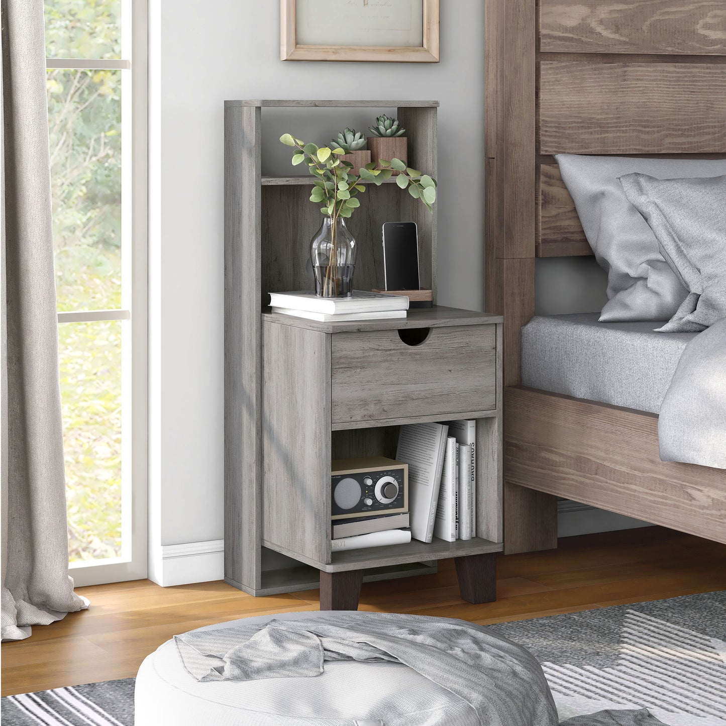 Right angled transitional vintage gray oak three-shelf nightstand with one drawer in a bedroom with accessories