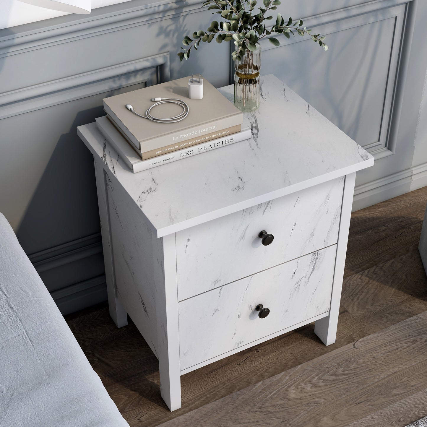 Right angled bird's eye view of a transitional white faux marble two-drawer nightstand in a bedroom with accessories