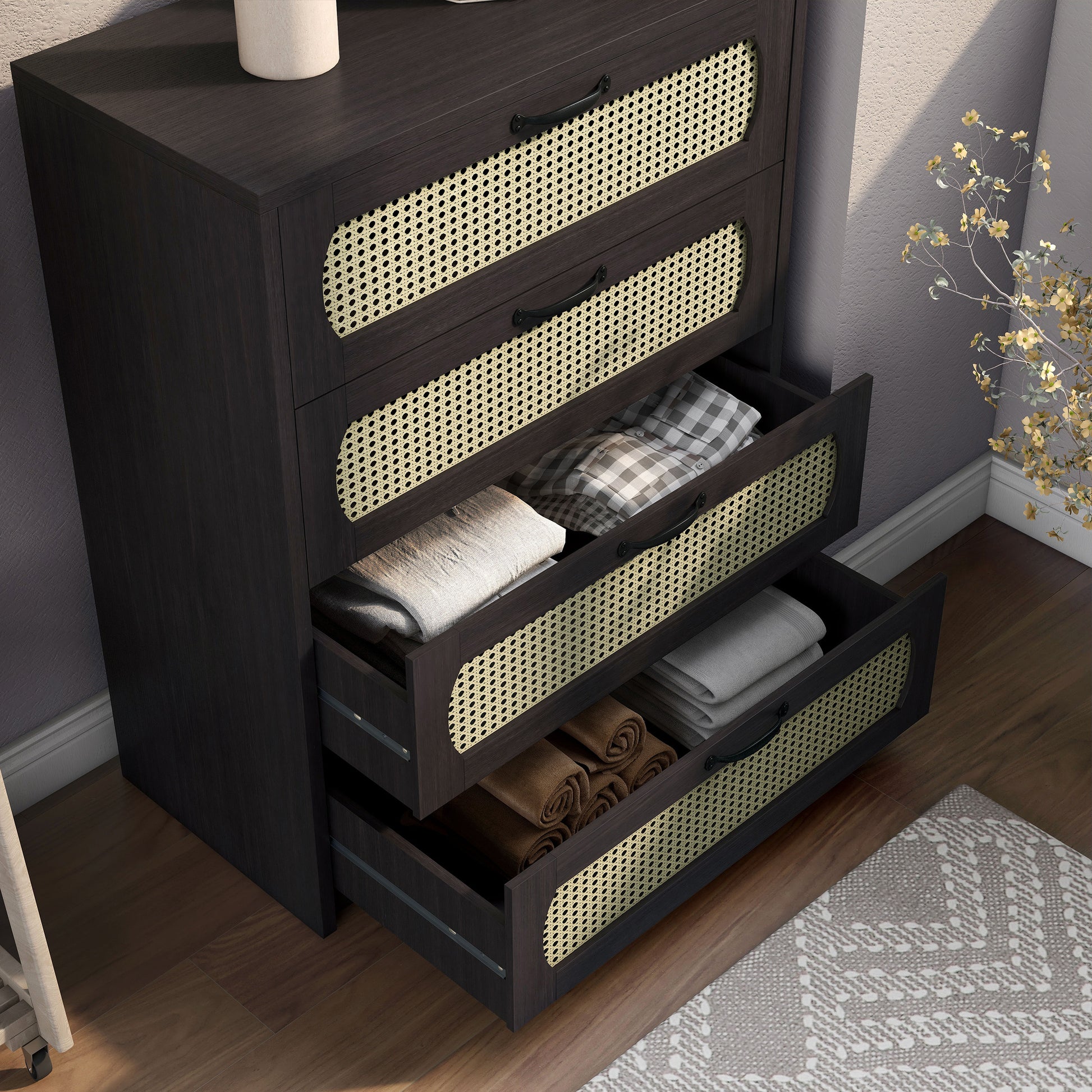 Right angled bird's eye view of a bohemian espresso and rattan four-drawer mini chest cabinet with two drawers open in a bedroom with accessories