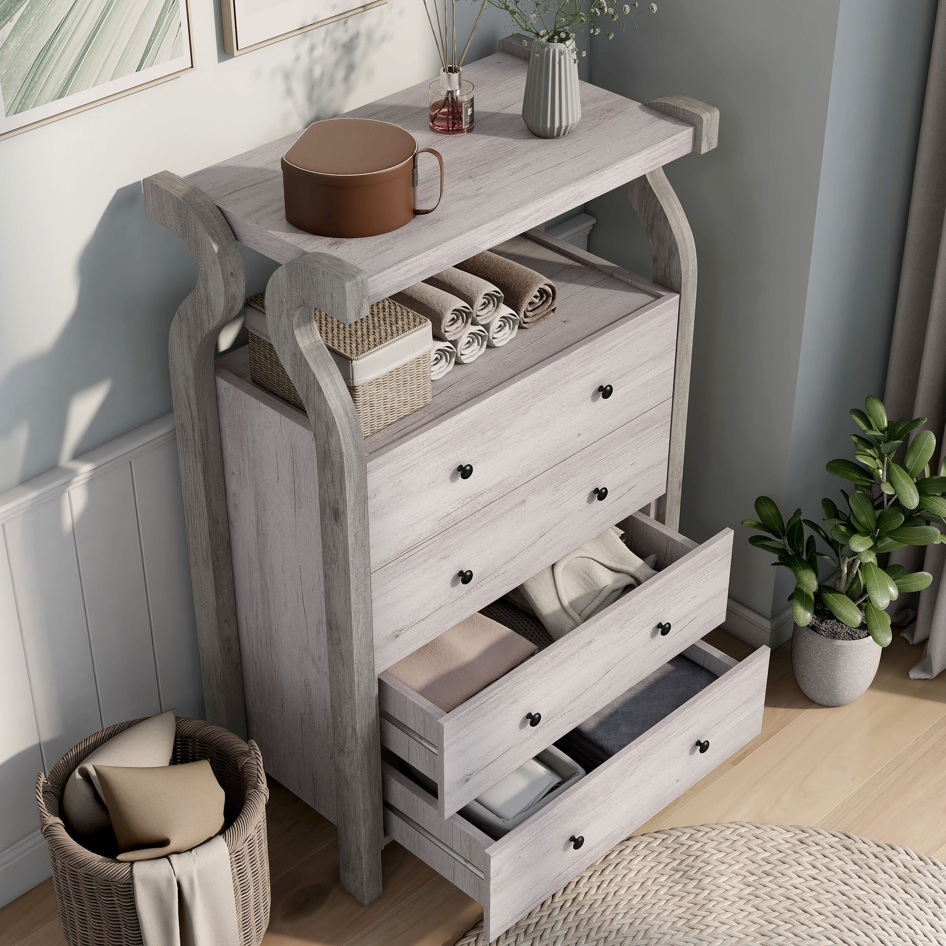 Right angled bird's eye view of a transitional coastal white four-drawer tall dresser with a shelf and two drawers open in a bedroom with accessories