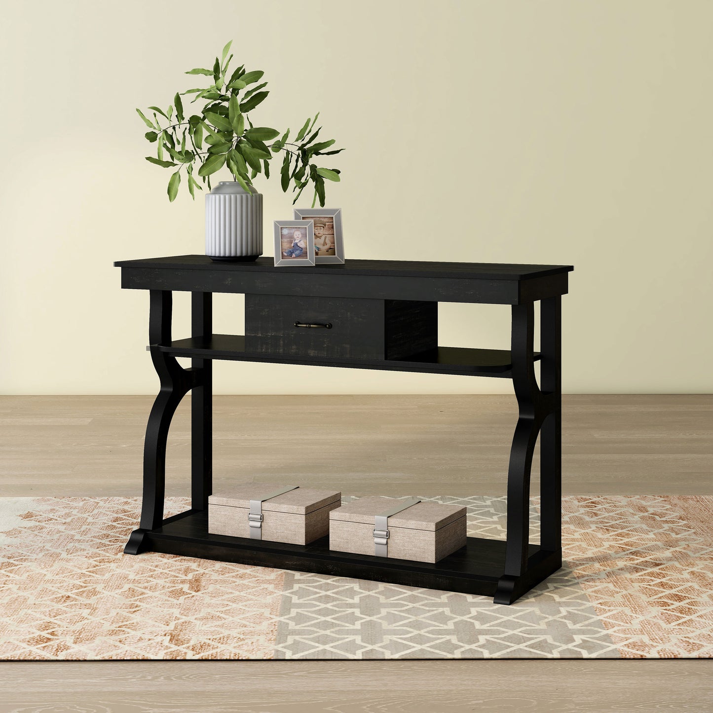Left angled farmhouse reclaimed black oak three-shelf storage console table with a drawer on an area rug with accessories