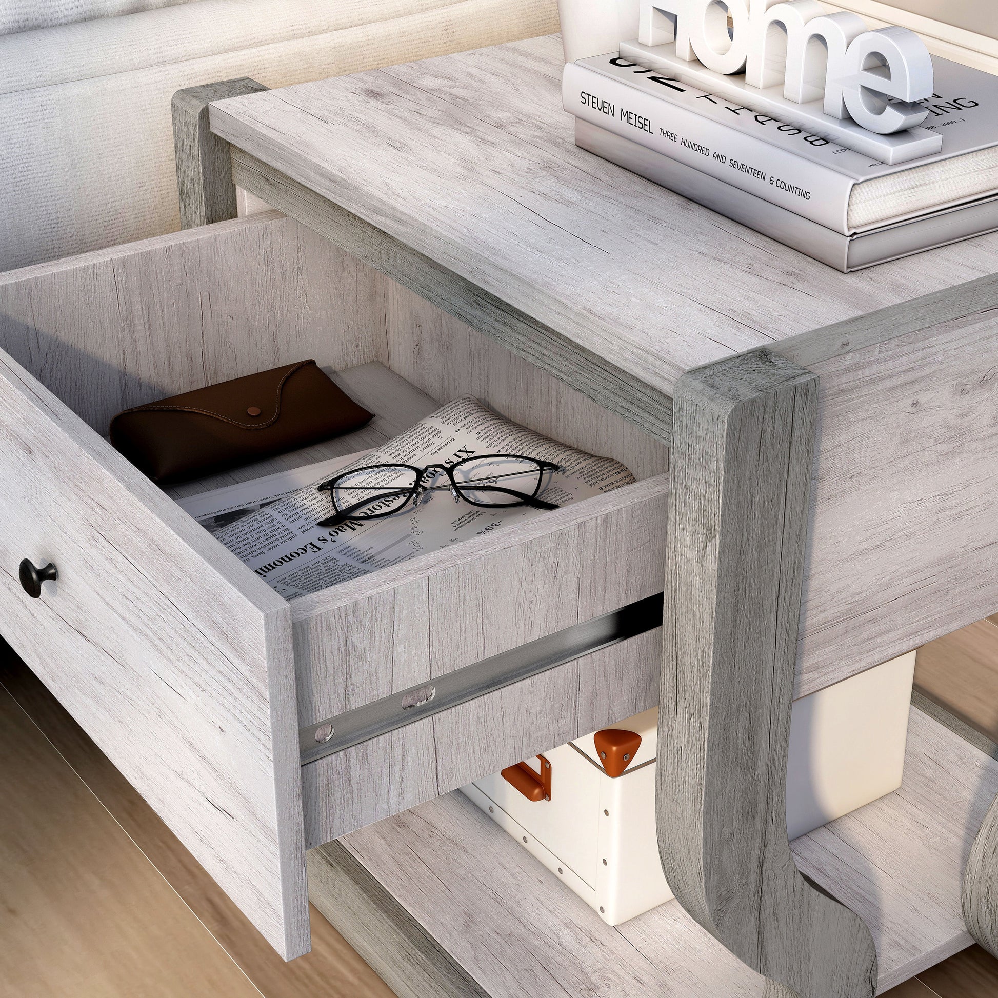 Left angled close-up view of a transitional coastal white one-drawer side table with a shelf and drawer open in a living room with accessories
