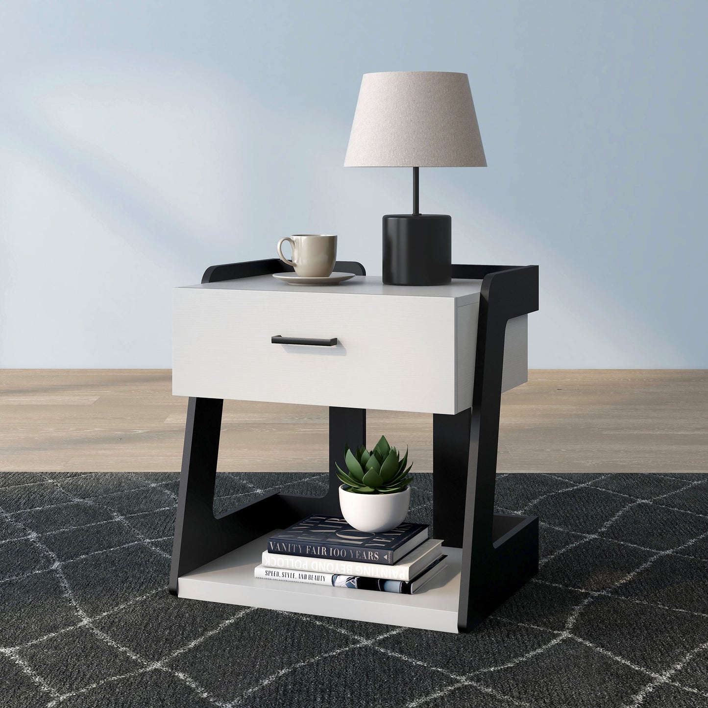 Left angled contemporary white and black one-drawer side table with a shelf on an area rug with accessories